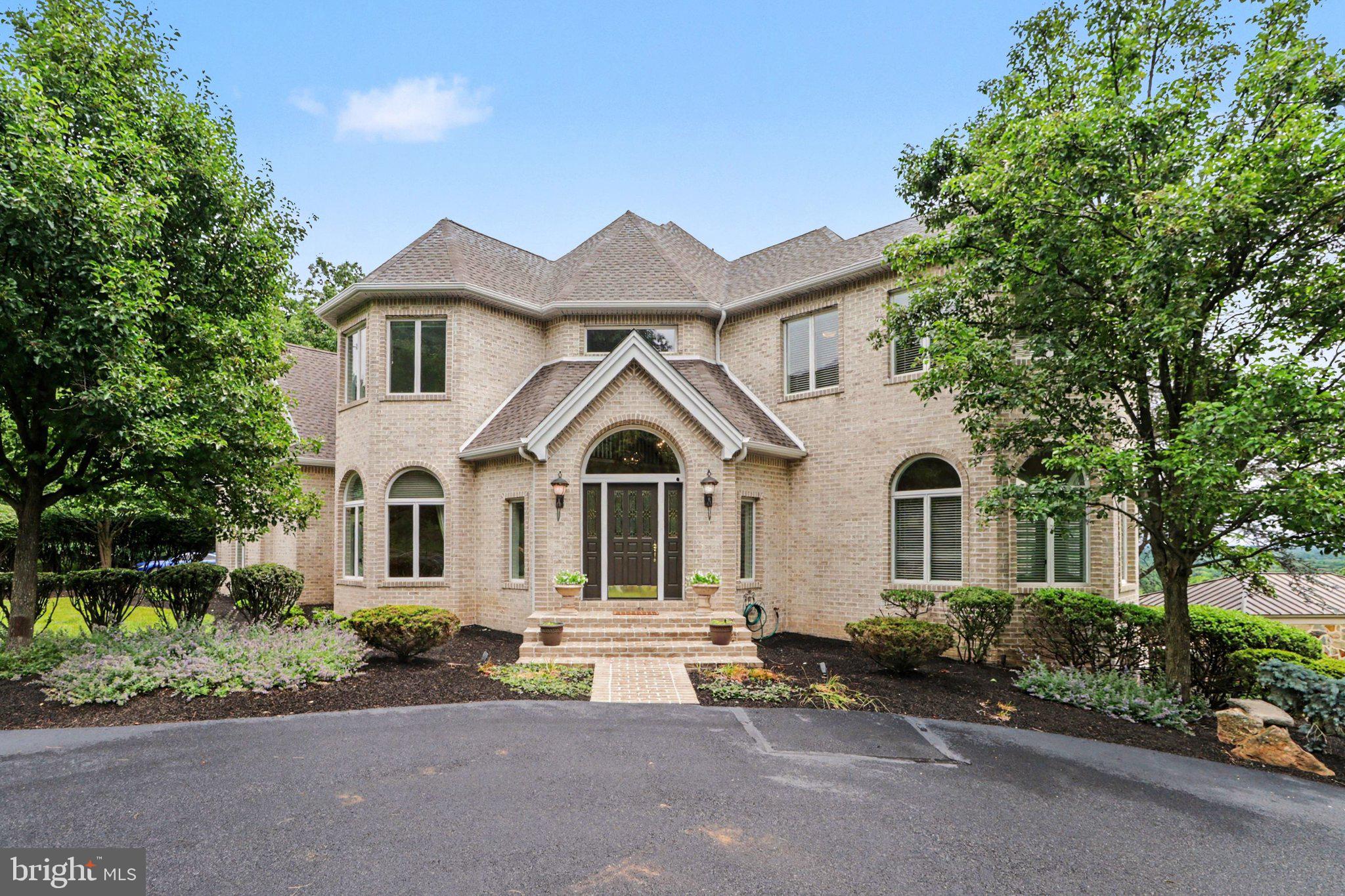 Perched on Blue Mountain with breathtaking views from the exquisite in-ground pool & entertainment area, upper deck  and primary suite, this remarkable all-brick Yingst luxury home blends a matchless vista with timeless craftsmanship and exceptional comfort. Offering over 6,400 square feet of beautifully finished living space, every detail was thoughtfully designed for both elegant entertaining and everyday living.
Inside, soaring 10-foot ceilings, rich hardwood flooring, and refined architectural details create a warm and sophisticated atmosphere. The formal living and dining rooms are perfect for hosting, while the expansive chef’s kitchen is complete with natural curly maple cabinets, granite island, additional vegetable sink, butlers pantry, separate dining area and built-in desk serves as the heart of the home. A bright sunroom with wet bar provides the perfect place to relax.
Upstairs, the luxurious primary suite features a tray ceiling and spa-inspired bath with soaking tub, alongside three additional bedrooms, two full baths, and an exercise room. The finished walk-out lower level adds even more living space with a cozy family room, custom bookshelves, additional bedroom suite offers privacy and flexibility for guests or multi-generational living, and wine cellar.
Outside, the home transforms into a private retreat with a wraparound deck overlooking the valley, a custom heated saltwater pool, and a custom pavilion with outdoor kitchen designed for unforgettable gatherings. With a new roof, new carpeting, solid wood doors, rear-entry 3-car garage, and countless additional upgrades throughout, this is more than a home, it’s a lifestyle. A joy to own.