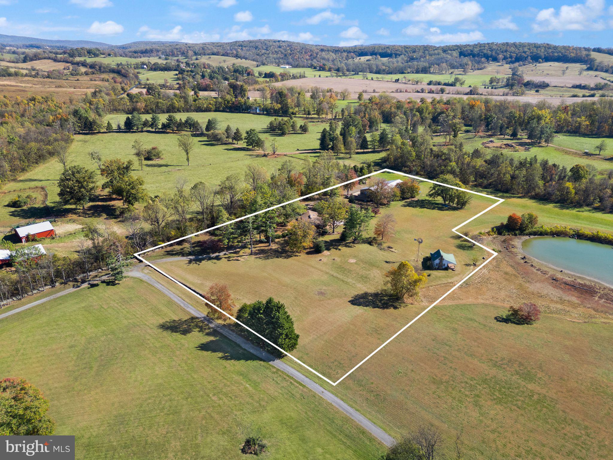 Previously priced without including the fishing shack!!!!!!!  NOW selling the existing home, workout/recreation building, personal storage/workshop building, and fishing shack on a total of 7.45 acres. The pond is not part of the sale.  
A rare opportunity to own a custom mid-century modern home set on a private 7.45-acre parcel in Warrenton, VA—complete with a massive storage/workshop building and a recreation facility featuring a gym/pool house with a full bathroom. This architecturally unique home showcases vaulted wood-beamed ceilings, walls of glass, and open living spaces that seamlessly connect with the natural surroundings. While the home may benefit from updates, it offers exceptional potential in a highly desirable location.

The main level features a dramatic great room with panoramic views, a floor-to-ceiling brick fireplace, and access to an oversized deck—perfect for entertaining or enjoying peaceful sunsets. The open kitchen includes natural wood cabinetry and a center island, offering a solid foundation for modern upgrades.

Also included is a county-approved personal storage/workshop building featuring a second-floor apartment with one bedroom, full bath, full kitchen, and washer/dryer hookups, along with a separate office/library space complete with a full bath and kitchenette. The apartment is approved as a second dwelling (ADU).  

The fishing shack is a truly one-of-a-kind standalone retreat featuring vaulted ceilings, a massive floor-to-ceiling wood-burning fireplace, bedroom loft, kitchenette, and full bathroom. Rustic charm meets cozy comfort, creating the feeling of walking into a Bass Pro Shop lodge tucked away in nature.
