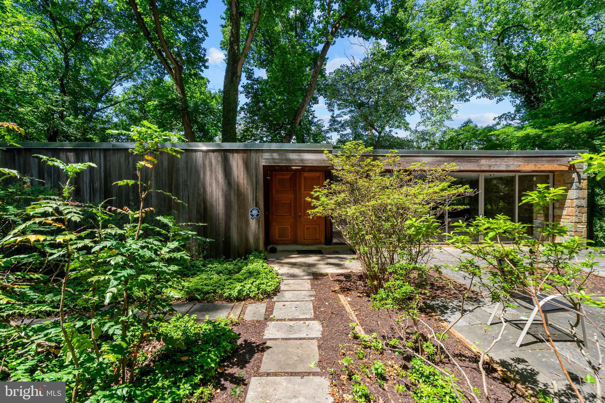Nestled into the wooded hillside of Rocky Brook Park, 401 Willington Drive is a remarkable custom mid-century modern residence that perfectly captures the designs of Breuer, Johnson and Kahn. Set on more than an acre of wooded, private grounds in Silver Spring, this architectural gem is being offered for sale by its original owners and presents a rare opportunity to own a truly special architectural retreat surrounded by nature.

Inspired by the design of architect Albert Preston Moore’s own home in Greenwich, Connecticut—featured in the April 1959 issue of Architectural Record—the residence, sited on a 1.14-acre lot reflects the clean lines, thoughtful proportions, and seamless indoor-outdoor connection that define the best of mid-century modern design.

Defined by iconic flat rooflines, warm natural materials, and dramatic walls of glass, the home was thoughtfully designed by the Fine family to blur the line between indoors and out. Expansive windows and sliding glass doors frame tranquil woodland views, filling the interiors with natural light and creating a seamless connection to the surrounding landscape.

The stunning main living space is anchored by an extraordinary floor-to-ceiling stone fireplace wall built with local Carderock stone, slate flooring, and expansive glass overlooking the private gardens and mature trees beyond. Rich wood tones, clean architectural lines, and open entertaining spaces create a warm yet sophisticated atmosphere that is both inviting and distinctly mid-century.

A variety of woods are used throughout the house, from the exterior redwood cladding to the original teak cabinets in the kitchen, to the cherry walls, walnut doors, rosewood door handles and oak parquet flooring. The front doors are from the National Gallery of Art while wood rafters were crafted from the bleachers from JFK's inauguration. Customized Shoji screens lend the house a Japanese aesthetic, reflecting the garden design while reinforcing the geometrical priority of mid-century design.

With 5 bedrooms, 2 full bathrooms, and 1 half bath, the home offers exceptional flexibility for modern living, whether hosting guests, working from home, or creating private personal spaces. Radiant heating warms the entire house during winter. A custom detached three-car garage is a rare and valuable addition, offering exceptional space for collectors, hobbyists, or auto enthusiasts while enhancing the home’s private estate-like setting.

The Rocky Brook Park/Quaint Acres area is one of those “hidden gem” pockets of Silver Spring that feels much more wooded and secluded than most close-in DC suburbs.

It’s known for large wooded lots, custom mid-century homes, winding streets, and a strong connection to nature. Many homes were built from the late 1940s through the 1960s, with a notable concentration of custom-designed mid-century modern houses—rather than repetitive tract homes—so no two properties feel exactly alike.

The area borders the wooded stream corridors of the Northwest Branch watershed, giving it a more natural, almost semi-rural feel than many nearby subdivisions. This makes it especially appealing to buyers looking for privacy, mature landscaping, and architecture with character rather than newer subdivision-style homes.

Just minutes from downtown Silver Spring, major commuter routes, and Washington, DC, 401 Willington Drive offers the rare combination of privacy, architectural significance, and everyday convenience—a true hidden sanctuary in one of the area’s most distinctive neighborhoods. (Square footage is approximate and should not be used for property valuation.)