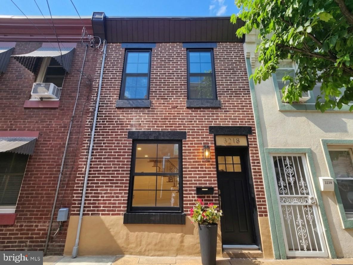 Wait until you step inside this one. Nestled among the charming rowhomes of Port Richmond, 3218 Miller Street is a beautifully renovated gem where thoughtful design and quality craftsmanship shine throughout. Step inside this sun filled row and you'll immediately appreciate the custom touches that make this home stand apart, including newly installed bamboo floors, custom built ins with a fireplace, an original iron banister, exposed brick accents, and brand new black modern windows. The inviting layout flows seamlessly from the living and dining areas into the open kitchen, where a striking exposed brick wall adds warmth and character. Featuring white shaker cabinetry, quartz countertops, stainless steel appliances, and a full light glass door that fills the space with more natural sunlight where it seamlessly transition to outdoor living.

Just beyond the kitchen awaits your own private courtyard oasis. Newly installed stone pavers create a charming foundation for outdoor dining, morning coffee, gardening, or hosting intimate gatherings. Upstairs, you'll find two thoughtfully finished bedrooms and two beautifully updated full bathrooms, each designed with its own distinct style, from elegant gold accents and a stone shower floor to sleek black fixtures and contemporary finishes. One of the bedrooms features an exposed brick accent wall, adding even more character and charm. The partially finished basement also offers valuable flex space perfect for a home office, workout area, media room, or additional lounge space.

Additional upgrades include a new HVAC system with central air conditioning, an updated electrical panel, and quality improvements throughout. Ideally situated just steps from Campbell Square Park, Her Daughters cafe, La Roma, Miles Table, neighborhood delis, pizzerias, and local favorites. With easy access to public transportation, I 95, Allegheny Avenue, Fishtown, Northern Liberties, and Center City, this move in ready home offers the perfect blend of character, comfort, and convenience in the heart of Port Richmond.