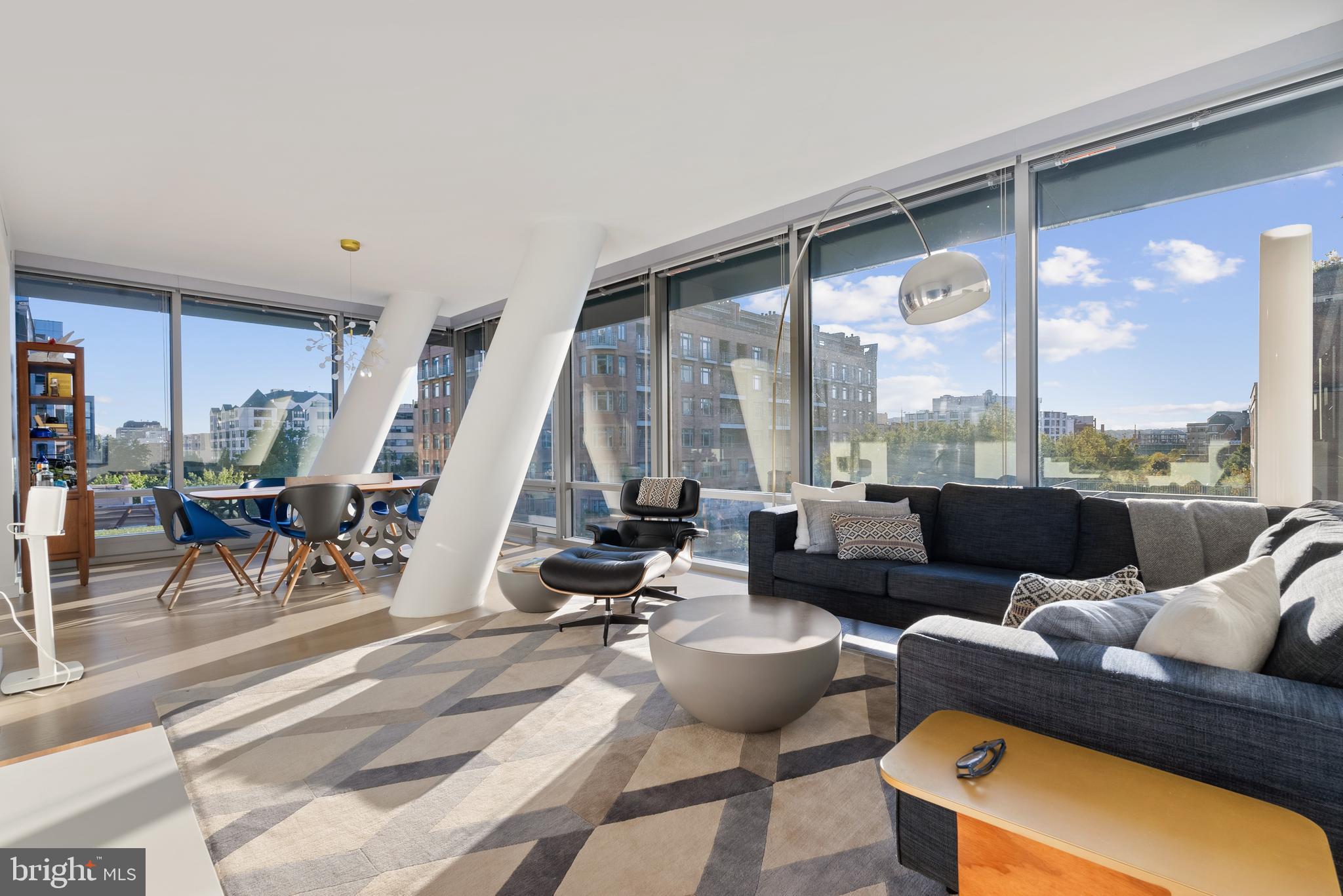 As one of the few coveted corner residences in Westlight, Residence 53 offers an unmatched sense of openness and privacy. Triple-glazed floor-to-ceiling window walls—rated at an impressive Sound Transmission Class (STC) 42, quieter than most airports—wrap the home in natural light and frame sweeping city and treetop views. Each window is fitted with custom automatic shades for precision light control. Wide-plank natural oak floors ground the space, while the fluid open layout invites effortless entertaining. The kitchen balances form and function with Italian high-gloss cabinetry, quartzite countertops, and integrated Bosch and Thermador appliances. Natural-gas cooking vents directly to the outside—an uncommon luxury in city residences.

Each of the three bedrooms is a sanctuary lit through those same acoustically superior windows with custom shades. The primary suite offers blackout shades for the most luxurious sleep. Generous closets including a custom walk-in, and a spa-inspired bath featuring Waterworks fixtures and a teak-slatted shower floor round out the spacious suite.

LEED Gold certified, Westlight provides HEPA-grade fresh air and near-silent interiors—a rare standard of urban wellness. The dramatic lobby, anchored by a 50-foot living green wall, sets a tranquil tone the moment you arrive.

Residents enjoy 24/7 concierge, doorman, porter, and onsite engineer services. Amenities include a state-of-the-art fitness center with Peloton and Technogym equipment, dog-wash station, and bicycle storage. Residence 53 conveys with two private, controlled-access garage spaces near the e-charging station and a secure storage space.

Unwind or entertain atop D.C.’s only 25-meter rooftop pool, complete with grill terrace and clubroom with catering kitchen. With Michelin-guide dining (Nobu, Blue Duck Tavern, Rasika), the Kennedy Center, Downtown, and Dupont art galleries just blocks away.