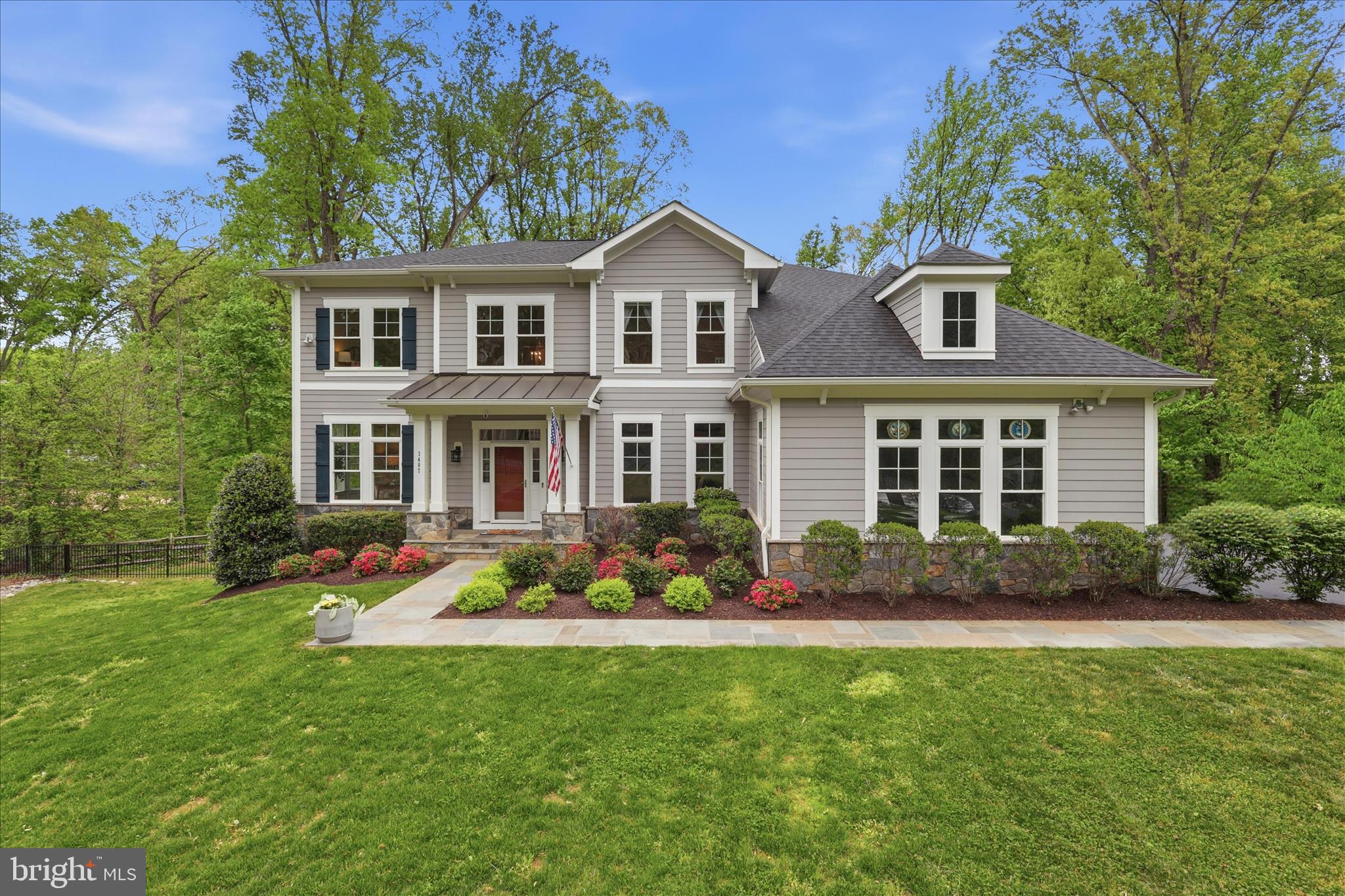 Welcome home to Barkley Oak, an exceptional 2019 Stanley Martin Craftsman residence set on nearly an acre in the heart of Mantua. From the moment you arrive, the gated entrance—framed by custom stone pillars and elegant lantern lighting—creates a grand and memorable first impression. Offering over 6,000 square feet of beautifully finished living space, this thoughtfully designed home features 6 bedrooms and 5.5 bathrooms, including a convenient main-level bedroom with a full bath. With 10-foot ceilings, a three-car garage w/EV charging, and a fully finished walkout lower level complete with a kitchenette, every detail has been carefully considered for both comfort and functionality. Inside, the home showcases high-end finishes, extensive millwork, and refined trim upgrades that elevate the open-concept layout—perfect for both everyday living and effortless entertaining. A dramatic two-story foyer welcomes you with gleaming hand scraped hardwood floors, leading to a gracious living room and an elegant dining room ideal for hosting gatherings. The gourmet kitchen is a true centerpiece, featuring quartz countertops, white soft-close cabinetry, stainless steel appliances including a double oven and gas range, a Butler’s pantry, and a spacious breakfast area. Step directly onto the Trex deck w/gas hookup for seamless indoor-outdoor entertaining.  The deck overlooks the expansive fully fenced backyard with mature trees, integrated smart multi-zone landscape lights and plenty of room to add a pool if desired. Just off the garage, a well-designed mudroom/drop zone keeps everything organized and out of sight. The adjoining family room impresses with soaring windows, abundant natural light, and a cozy gas fireplace. A powder room and the main-level ensuite bedroom add flexibility for guests or multi-generational living.
Upstairs, the luxurious primary suite offers a private retreat, complete with a sitting area, expansive walk-in closets, and a spa-inspired bathroom featuring a custom oversized shower, soaking tub, dual vanities, and a private water closet. Three additional generously sized bedrooms—one with an ensuite bath—plus another full bath and an upper-level laundry room complete this level. The finished walkout basement with 9ft ceilings and full size above grade windows expands your living space with a large recreation room, kitchenette, an additional bedroom and full bath, a bonus room, and a workshop with ample storage. Filled with natural light and designed for year-round enjoyment, this home truly has it all. A rare offering, Barkley Oak delivers the feel of a private estate while remaining just moments from everything Northern Virginia has to offer—an extraordinary blend of space, privacy, and timeless refinement.  Enjoy close proximity to the highly sought after Mantua Swim and Tennis Club and the Cross County Trail.  Ideally located just outside the Beltway with easy access to Routes 50, 66, and I-395, minutes to Inova Fairfax Hospital, Dunn Loring and Vienna Metros, and only 5 minutes to the Mosaic District with its vibrant shopping and dining. Zoned for the highly sought after Woodson High School.