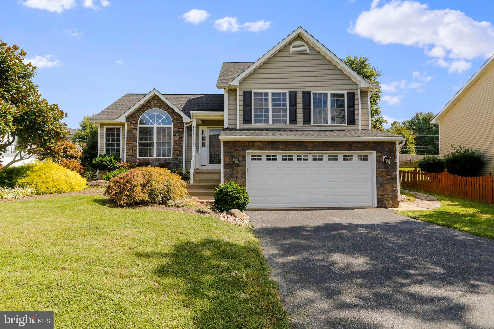 This attractive stone-front home with beautifully landscaped outdoor space is ready for immediate move in! At the end of the street, so no through traffic. Fully fenced backyard with deck, pergola, firepit, and storage shed. Trees and landscaping create privacy. Inside, you'll find hardwood floors and kitchen with stainless appliances and granite countertops. Family room has vaulted ceiling. There are three beds and two baths upstairs, including primary suite with double sink, soaking tub, and walk-in closet. Two car garage and paved driveway provide plenty of parking options. Work from home using highspeed internet available through Comcast/Xfinity. Excellent location just minutes from downtown Charles Town and right off 340 for easy commuting!