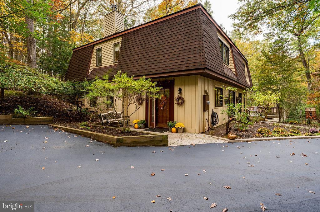 Experience serene quiet living on this exquisite 3-bedroom, 2-bath French-inspired home, perfectly situated on a private 1.73-acre wooded lot alive with wildlife. Nestled in a secluded development, this home blends timeless charm with modern comforts, featuring gleaming hardwood floors and an updated kitchen complete with a farm sink, subway tile backsplash, and all appliances included. Thoughtful updates over the past five years include a new roof, hot water heater, and elegant doors, including a back slider that opens to a wooden deck overlooking the peaceful landscape.  The upstairs features a spacious master bedroom with plenty of closet space, two additional bedrooms, and a  main bath with jacuzzi tub.  A  cozy loft ideal for relaxing and watching television completes the upstairs. A 2-car garage with an attached art studio offers creativity and functionality, while outdoor amenities like a fire pit and shed make entertaining and storage effortless. This home is a rare opportunity to enjoy privacy, style, and nature in perfect harmony. This property is by appointment only, please no drive-bys as the community is small and private.