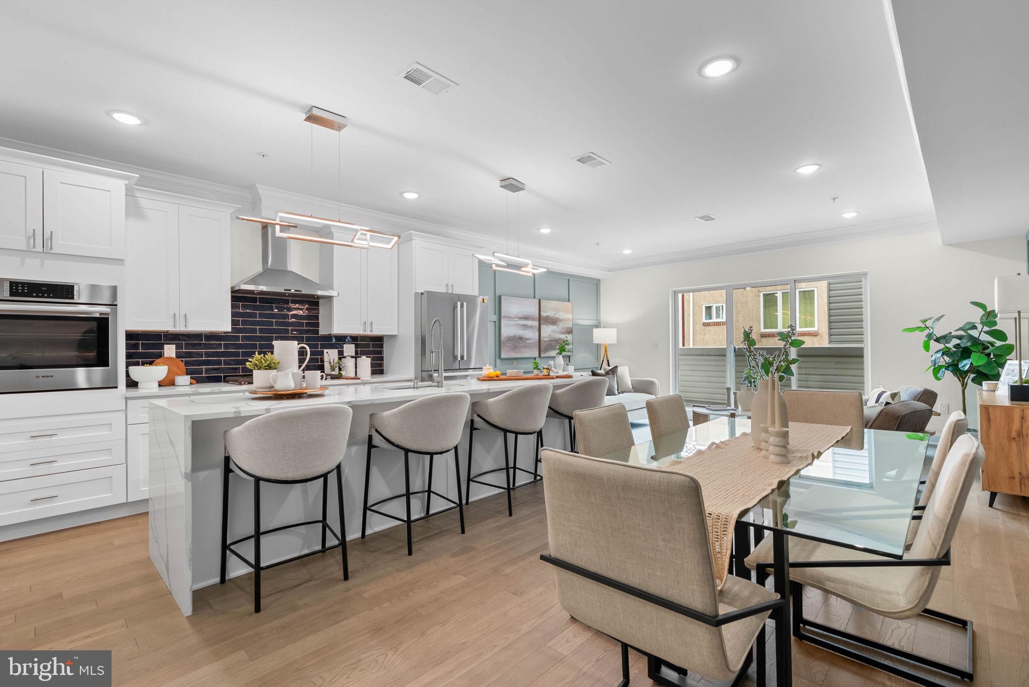 On a quiet, tree-lined block in one of Philly's most sought-after pockets, where Pennsport blends into Queen Village, you'll find 107 Ellsworth St. This modern, luxurious, 4-bedroom, 4-bathroom residence spans over 2,400 square feet and includes a 2-car garage, a finished basement, and a private roof deck. It's one of just five homes crafted by a top Philadelphia developer, known for their quality construction and attention to detail. A striking brick facade welcomes you into a sunlit entryway, with a second entrance conveniently located off the garage. On the main level, wide-plank hardwood floors run throughout an open layout filled with natural light, thanks to oversized windows. The standout kitchen is sleek and all-white, fitted with premium Bosch stainless steel appliances, classic shaker cabinetry, and a large island with seating. A bold blue subway tile backsplash adds a splash of color and character. A board and batten feature wall extends from the dining area to the bright and airy living room, where sliding doors lead out to a private terrace. This floor also includes a sleek full bathroom wrapped in dramatic black tile and a spacious bedroom with tall windows. Upstairs on the third level, you'll find another full bedroom and bathroom at the front. Past the laundry closet is a large primary suite, offering a calm, hotel-like retreat. It features a generously sized bedroom, a walk-in closet, and a beautifully designed bathroom with monochrome black tile, a double vanity, soaking tub, and a glass-enclosed shower. The finished basement has extra living space perfect for a media room, home gym, or playroom. There's also another bedroom suite with its own full bathroom. On top of it all is an expansive roof deck where you can host friends and family, while admiring the panoramic view. Utilities include central A/C, gas heat, and a tankless gas water heater. The location boasts an impressive Walk Score of 99, placing you within steps of popular restaurants and friendly shops along Moyamensing Ave. It's close to sprawling Jefferson Square Park, and there's easy access to shopping on Columbus Blvd, public transit, Washington Ave, I-95, and South Jersey. Schedule your tour today!  Enjoy the 10 year tax abatement starting 2026!