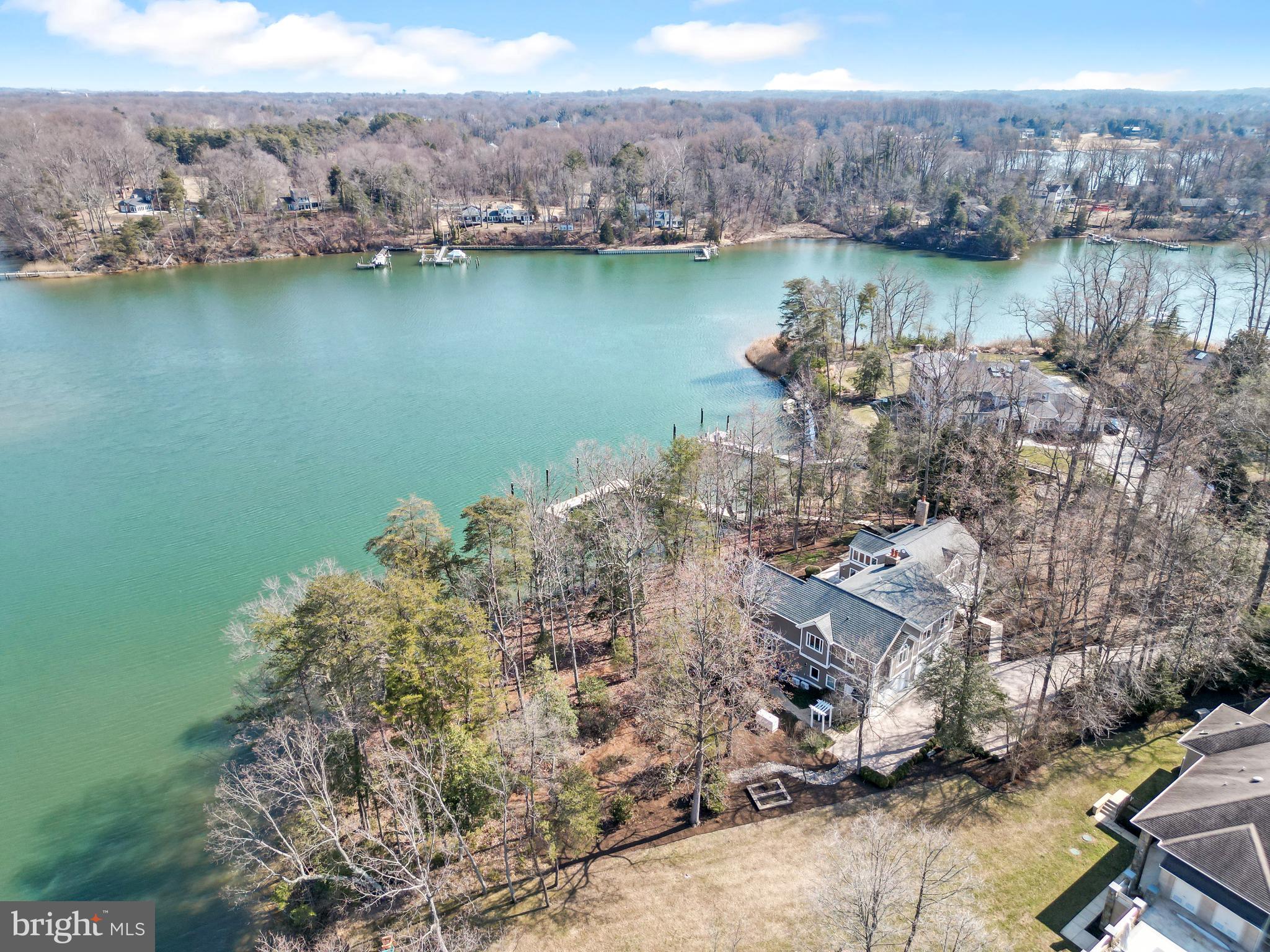 Privately set on 1.25 acres with approximately 350 feet of protected waterfront on Church Creek, this exceptional Poplar Point estate offers a rare deep-water setting just moments from the South River. The private pier is designed for serious boating, featuring 8.5’–10’ water depth, water and electric service, four slips, two boat lifts (including a 12,000-lb lift and swinger lift), and capacity to accommodate yachts up to 70 feet.

Positioned along a gentle bend leading to the South River, the property enjoys the best of both worlds—direct access to open water with the protection of calm creek waters, ideal for boating, paddleboarding, swimming, and a relaxed waterfront lifestyle.

A paver driveway introduces a residence thoughtfully designed for both comfort and longevity. Encompassing approximately 6,625 finished square feet, the home offers generous yet comfortable living spaces designed to capture water views from nearly every vantage point. Outdoor living is central to the experience, featuring expansive IPE hardwood decking, multiple balconies, and a heated lap pool, all oriented toward the tranquil waterfront setting.

Inside, radiant heated floors throughout, Brazilian hardwood floors, custom maple doors, and walls of windows frame water views from nearly every room. The great room impresses with a vaulted cedar ceiling, masonry fireplace, wet bar, and French doors opening to the waterfront deck, creating an inviting space for both entertaining and everyday living.

Additional gathering spaces include a main-level living room with stone fireplace and bar area, along with a versatile sunroom filled with natural light. The kitchen offers granite countertops, stainless steel appliances, an island with secondary sink, and seamless access to outdoor dining areas. A main-level bedroom and full bath provide flexibility for guests, while the four-car garage supports an active waterfront lifestyle.

Upstairs, the owner’s suite serves as a private retreat, capturing panoramic water views from a private IPE balcony. The spa-inspired bath features radiant heated floors, soaking tub, glass-enclosed stone shower, and two custom walk-in closets. In total, five bedrooms and four full baths occupy the upper level, complemented by a vaulted second-level gathering room with fireplace and deck access.

Offering extraordinary waterfront frontage, rare deep water, and yacht-ready pier facilities, this residence represents a unique opportunity to experience refined living with luxurious comfort along one of the South River’s most desirable waterways.