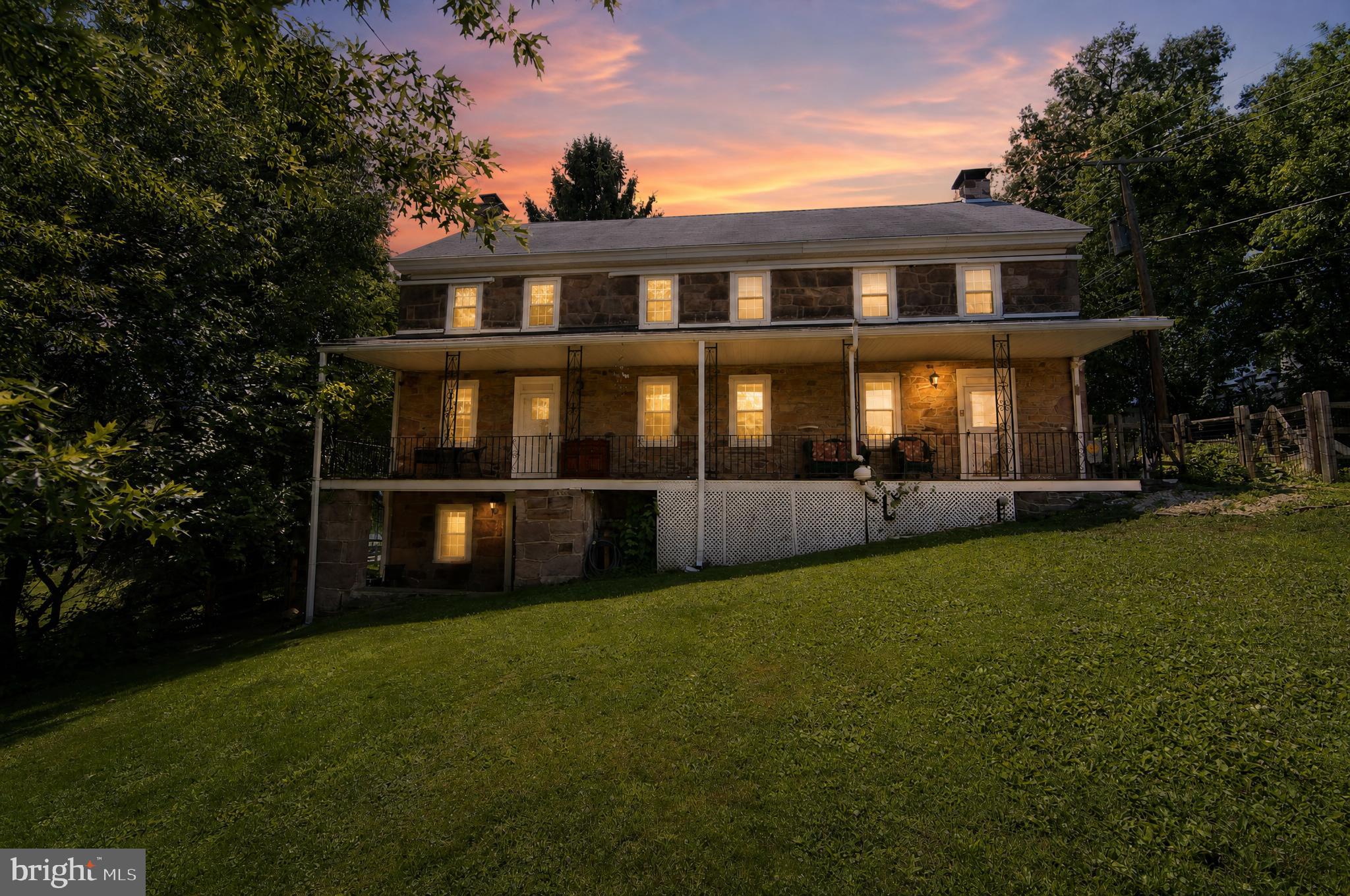 Welcome to 238 Brown Street, a truly one-of-a-kind 1812 historic home offering remarkable flexibility, timeless character, and a story all its own. Long rumored to have once served as the Springville Inn and Stagecoach Stop, this expansive property beautifully preserves the craftsmanship and charm of a bygone era while seamlessly incorporating the modern updates today's homeowners appreciate. Rich in original character and complemented by significant investments in comfort, efficiency, and functionality, this is a rare opportunity to enjoy the best of both worlds. The current owner has thoughtfully upgraded the home to provide modern ease to maintaining and stewarding this incredible home. Highlights include adding 14 mini-split units throughout the home and a dual propane heating system; an incredible feature for a property of this age and size, a complete reimagining of the lower level into a versatile and magical living space. With multiple living areas, three separate entrances, 6 bedrooms, 5 bathrooms, a finished attic living space, a newly reimagined lower level, and a detached multi car garage, the home offers outstanding flexibility for a wide range of needs. The layout can function as one large single-family residence or provide separate, private spaces ideal for multigenerational living, guest quarters, work-from-home space, studio use, or other creative arrangements. A full-width covered Trex front porch welcomes you to the property and serves both front entrances. Inside the main living area, you will find generous room sizes, hardwood flooring, deep window sills, crown molding, chair rail detail, recessed lighting, and a beautiful stone wood-burning fireplace that anchors the living room. The dining room continues the same classic character and offers plenty of space for large gatherings. Toward the rear of the home, the kitchen features upgraded counters, wood-look plank flooring, 42-inch cabinetry, a breakfast nook, dishwasher, electric range/oven, built-in microwave, refrigerator and access to an oversized rear deck overlooking greenery. A powder room with marble flooring and a laundry room with storage and utility sink add everyday convenience.  One of the home’s standout spaces is the elongated kitchen and patio area, finished with hardwood flooring and a stone accent wall. It is an ideal reading room, library, sitting room, or quiet retreat. Upstairs, the main living quarters include a spacious primary suite with walk-in closet, exposed beams, crown molding, chair rail, ceiling fan, and a large private bath featuring an oversized jetted tub, stall shower with multiple shower heads, double vanity with marble top, heated towel rack, and tile flooring. The finished third floor adds even more usable space, complete with exposed beams, new carpeting, and a full bath. The additional living area offers its own front entrance from the porch and includes a living room/dining room/kitchenette-style space on the main level, with three bedrooms and a full hall bath upstairs. This portion of the home creates excellent separation while still remaining connected to the overall residence. The lower level has been completely revamped into one of the most useful and versatile areas of the property. With interior access or a private entrance it boasts a full bath, kitchenette area, second stone fireplace, and abundant finished living space. It offers exceptional potential as a private retreat, guest space, teen suite, hobby area, studio, or separate living quarters. For investors or those looking for mutli-family living, the home offers an array of possibilities as many of the areas are able to be sectioned off and included in one side or the other of the home. This property is truly unique and is looking for its next steward, whether that be someone looking to call this home or someone looking for a unique and versatile property with multi-family potential.