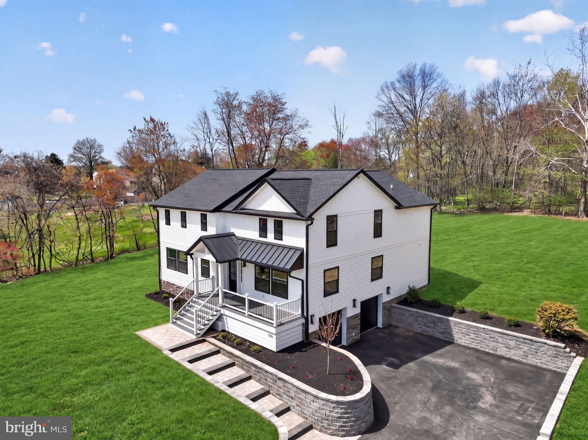 PRICED AGGRESSIVELY WITH INSTANT EQUITY!  RECENTLY APPRAISED FOR $1.25 MILLION.  Welcome home to your 4 BR, 2 full bath and 2 half bath Contemporary Farmhouse on over an acre of private, wooded land in the heart of Warrington. This complete rebuild with new addition features every imaginable custom upgrade.  The exterior features a grand entrance with a bespoke hardscape walkway, a welcoming front porch, vertical and horizontal siding, and elegant ledger stone accents.
Inside, every detail is designed for luxury—hardwood floors throughout, a massive gourmet kitchen with quartz countertops, marble backsplash, a massive waterfall island with pop up receptacles, soft-close shaker cabinetry, induction stovetop, double wall oven, and top-of-the-line stainless steel appliances. The kitchen features a walk-out sliding door onto your rear patio as well as entry the basement. 
The open-concept living and dining areas flow seamlessly, into the kitchen with a private family room or office accessed through double French doors, featuring a 3 sided recessed touchstone electric fireplace with vertical tile and area for a wall mounted TV and direct access to the first-floor powder room and large laundry room complete with cabinets and a quartz countertop for folding clothes.
The second floor is accessed by your custom solid wood staircase with a wood banister and wrought iron spindles.  Upstairs, the hardwood floor continues in the hallway and into your grand primary suite addition that has a vaulted ceiling, a spa-like five-piece bath with porcelain and marble tile throughout, a standalone soaking tub, and a custom double vanity with gold fixtures and a quartz countertop. The primary bedroom also has a large walk-in closet with custom shelving and recessed lighting. Three additional oversized bedrooms have plush Stainmaster carpet, contemporary fan lights, and oversized closets with closet organizers. The large full bathroom offers a double vanity with a quartz countertop, LED vanity lighting, an oversized tub with custom tile surround and shower niche, black matte fixtures and an oversized linen closet.
The fully finished basement offers extra living space with waterproof longboard vinyl flooring, a second powder room and access to your utility room. Every system is brand new—dual HVAC, all new electrical, plumbing, and insulation, plus a brand-new interior sprinkler system. The home also has all new windows, a new shingled and metal roof, all new doors and hardware, a new driveway with culverts, and both interior and exterior French drains for a watertight home. 
The oversized two-car garage with new garage doors equipped with garage openers offers direct access to the finished basement, making it easy to bring groceries to the kitchen. With recessed lighting inside and out, a bright lamppost, and serene natural surroundings where deer often roam, this home is the perfect blend of privacy, modern luxury.