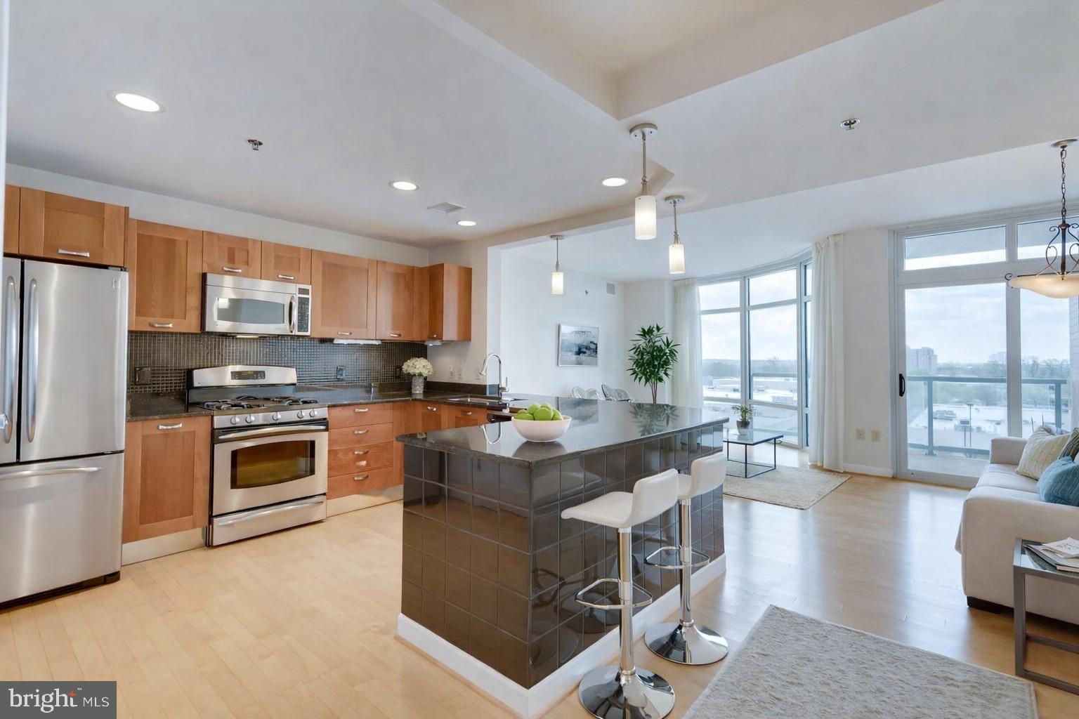 Welcome to this spacious 2 bedroom, 2 bath corner unit in the sought-after Midtown Bethesda North Condominiums, offering over 1,400 square feet of well-designed living space. Hardwood floors run throughout the main living areas, complemented by floor-to-ceiling windows that bring in abundant natural light. As a corner unit, the home enjoys added privacy and a larger balcony.

The open layout features a generous kitchen with stainless steel appliances, granite countertops, gas cooking, and ample cabinetry, along with a built-in dry bar ideal for entertaining. Custom shelving and thoughtfully designed storage areas are found throughout the unit, adding both function and convenience.

The primary bedroom includes a custom walk-in closet and an en-suite bath with dual vanities and a jetted shower. A new washer and dryer are located in-unit. One over-sized assigned parking space conveys, with an option to exchange for a parking space with a lift (2 spaces) through a separate deeded transaction for an additional fee.

Midtown Bethesda North offers a full suite of amenities, including concierge service, fitness center, rooftop pool, theater room, lounge areas, and more. Gas and water are included in the condo fee. Conveniently located near major access points, shopping, and a wide variety of restaurants.