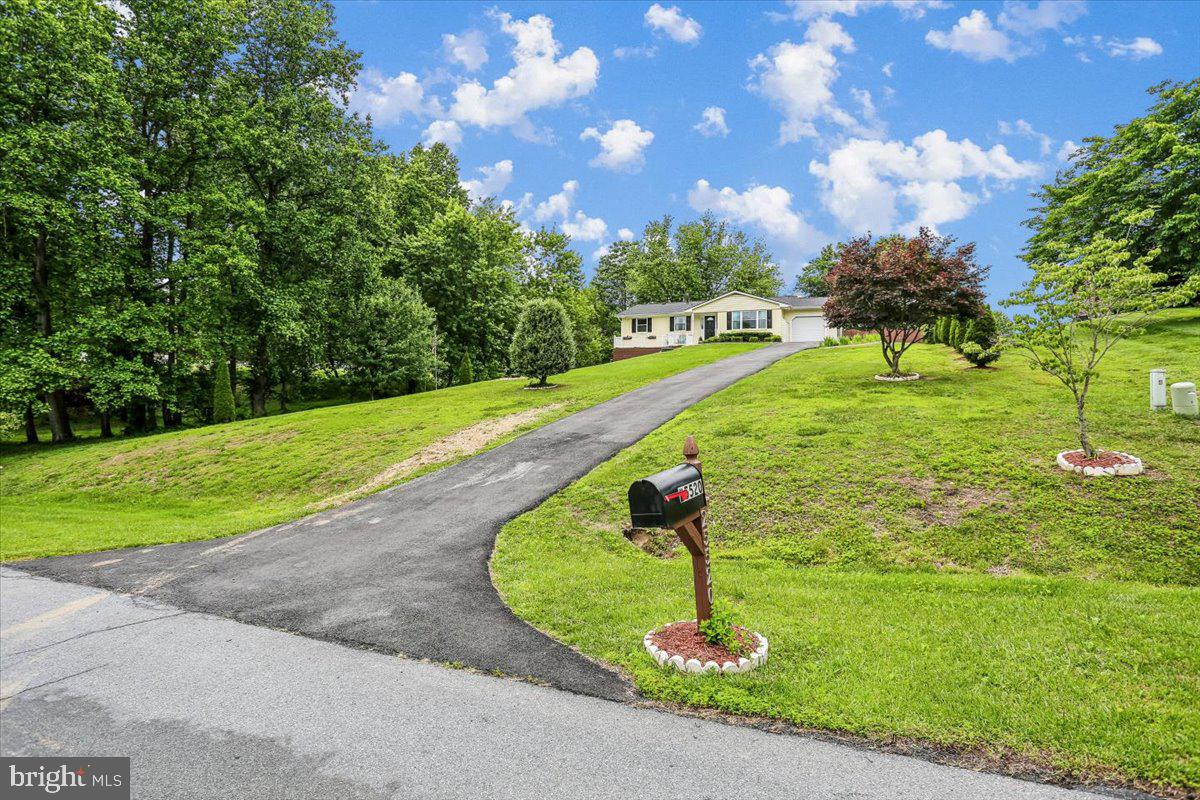 ASSUMABLE  VA  LOAN.    LOW INTEREST RATE!   Feel like you live in the country but have the convenience of living near town.  Bring the outside in with the many large windows and open layout.  The main level shows beautifully with the updated kitchen and lovely REFINISHED wood floors.  Enjoy quiet mornings in the breakfast area while looking out the picture window or end your day reclining while taking in the backyard view.  Inside or out, this house is perfect for entertaining , especially with the large deck and huge backyard.  The generous  finished walkout basement allows for endless possibilities.  Lower level carpeting replaced in 2024. The wood burning fireplace (with new insert) makes for an extra cozy basement.  The fourth bedroom and full bath in the lower level maintains privacy for overnight guests or multigenerational living.  LARGE shed with new roof for all the outdoor essentials.  Other big bonuses:  NEW ROOF,  NEW WATER SOFTENER, NEW REFRIGERATOR AND DISHWASHER,  NEW DRIVEWAY FINISH, NEW(ER) WASHER AND DRYER AND NO HOA.