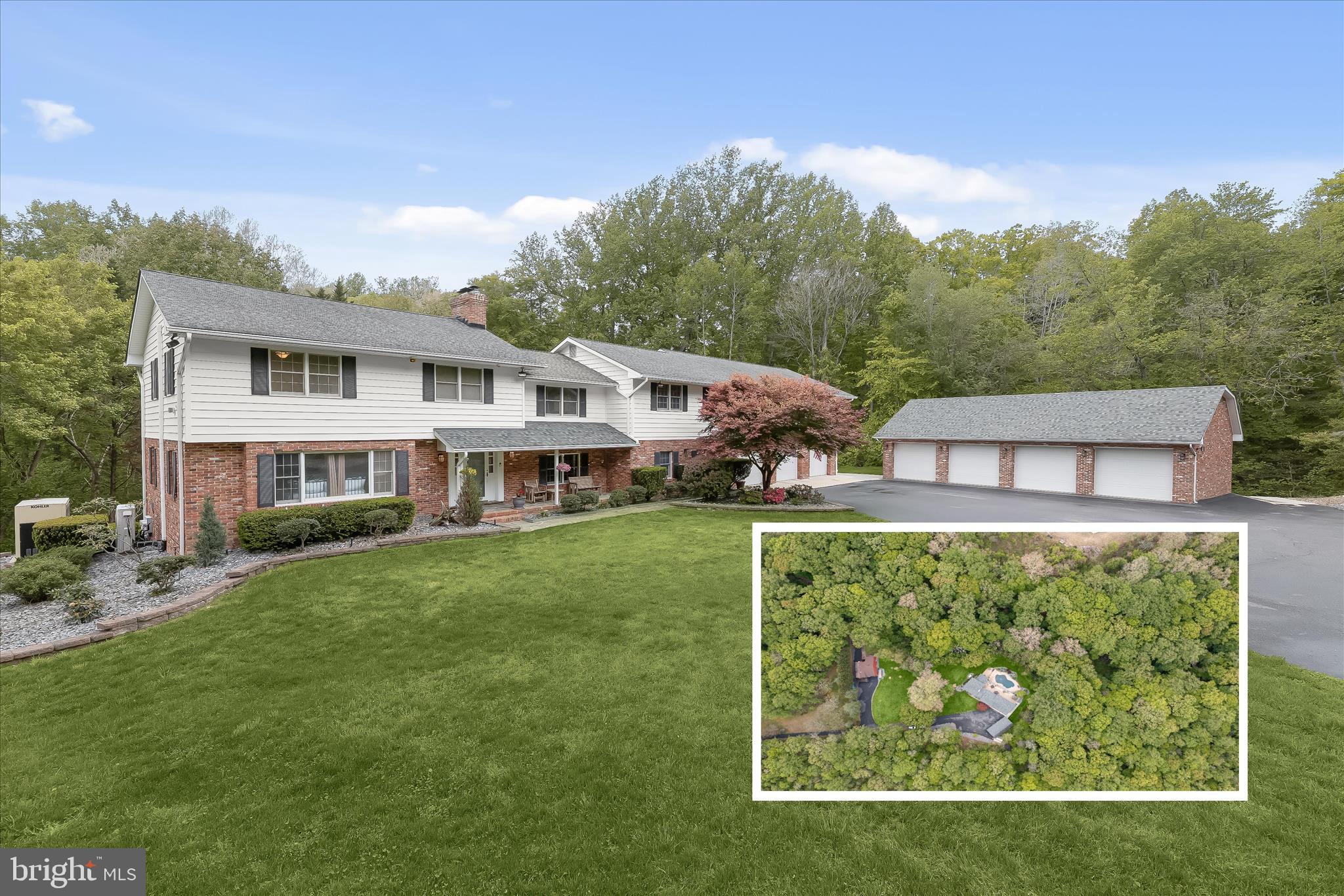 Set on 7.37 private acres and surrounded by mature trees, this expansive estate offers over 4,000 square feet of living space, a resort-style outdoor setting, and a rare combination of residential comfort and versatile outbuildings. Backing to the peaceful edge of the Patuxent River, the property is thoughtfully designed for both everyday living and multi-use flexibility, featuring an inground Gunite pool with hot tub, multiple garage structures, and separate metering that allows for income-producing or independent workspaces.
A gracious entry begins in the foyer, where a sweeping curved staircase and detailed box wainscoting create an elegant first impression. The recently remodeled kitchen serves as the heart of the home, appointed with a propane cooktop and range hood, high-end stainless steel appliances, double oven, apron-front sink, and quartz countertops. A large walk-in pantry with a sliding barn door adds both style and function. Just beyond, the dining room is framed by walls of windows that capture serene tree-lined views, enhanced by beamed ceilings and French door access to the deck for seamless indoor-outdoor flow.
The adjacent living room offers warmth and character with a brick-accented wood stove. A spacious recreation room extends the living space and is ideal for entertaining, complete with a built-in bar. A main-level bedroom provides flexibility for guests or multigenerational living and is paired with a beautifully renovated full bath featuring heated floors completed in 2020. A conveniently located half bath offers direct access to the pool area, making outdoor entertaining effortless.
Upstairs, the primary suite is a private retreat with a generous sitting room and a cozy fireplace set within a refined paneled wood surround. The suite also includes a large closet and a renovated en-suite bath with a double vanity and tiled shower. A unique highlight is the direct access from the primary suite to an expansive bonus area above the garage, currently configured as office space with four separate rooms, a kitchenette, full bath, and private entrance. This space is ideal for a studio or private workspace. Two additional upper-level bedrooms share a full hall bath.
The fully finished lower level adds even more versatility, featuring a kitchenette, full bath, and a flexible layout currently used as an exercise space. With full windows, a walk-out to the pool area, and a separate entrance, this level functions well as a potential apartment or guest suite.
Outside, the property continues to impress with multiple outbuildings, including a deep attached three-car garage, a detached four-car garage, a barn-style garage used for storage, and an additional detached garage with a tall door suited for RV storage, complete with its own HVAC system. A storage shed, irrigation system, whole-house generator, new water treatment system, and an oversized 119-gallon water heater support the home’s infrastructure. With three separate electric meters already in place, the property offers exceptional flexibility for those seeking to offset costs or create distinct living or working environments.
Located along Patuxent River Road in Davidsonville, this setting offers a quiet, rural feel while remaining convenient to everyday amenities. Shopping, dining, and services are easily accessible in nearby Crofton, Edgewater, and Annapolis, while outdoor recreation includes local parks, equestrian trails, and the surrounding Patuxent River and Chesapeake Bay waterways. Major commuter routes including Route 50, Route 301, and I-97 provide straightforward access to Washington, D.C., Baltimore, and Annapolis.