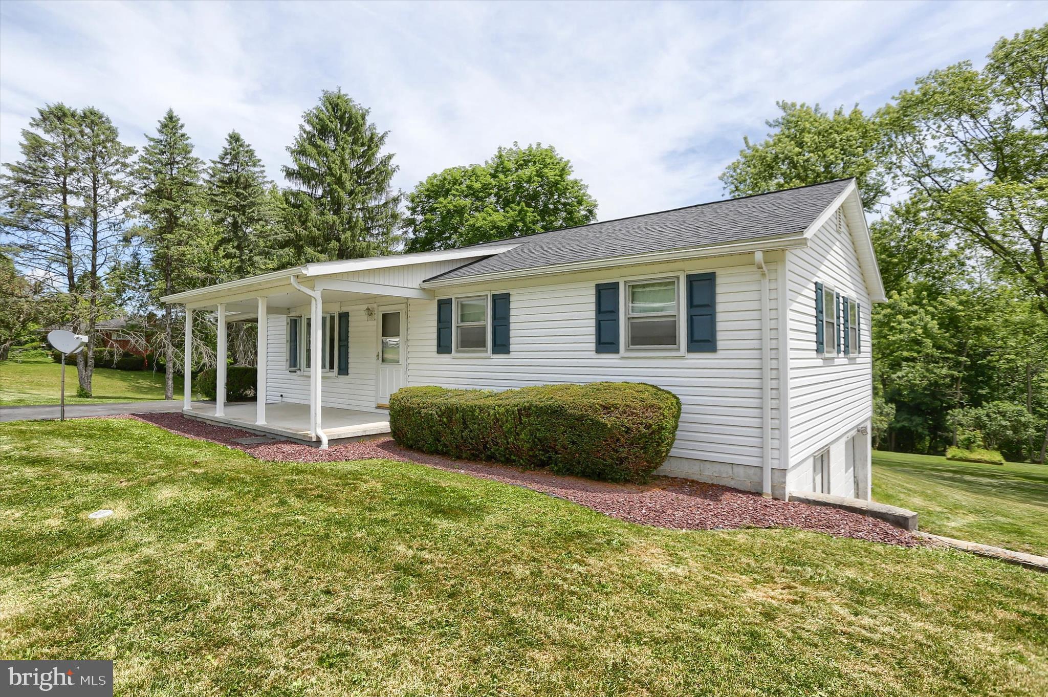 Welcome to 911 West St in Everett, PA—a charming 2-bedroom, 1-bath ranch that combines comfort, space, and a peaceful setting in a highly desirable neighborhood. This inviting home sits on a generous lot where neighboring properties are thoughtfully spaced, offering a sense of privacy that is often hard to find. The exterior presents classic appeal with light-colored siding, a covered front porch perfect for relaxing, and a wide, open yard that provides plenty of room for outdoor enjoyment. Practical features include a convenient carport and an attached oversized garage, complemented by a spacious driveway that easily accommodates multiple vehicles for guests or everyday living. With its easy one-level layout, appealing surroundings, and ample parking, this property creates an ideal opportunity for anyone seeking both simplicity and a tranquil residential atmosphere.