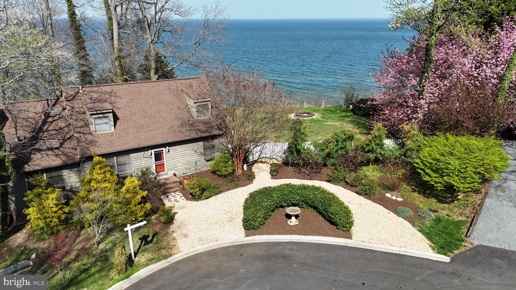Tucked at the end of a quiet cul-de-sac in Western Shores, this charming Cape Cod feels like a place where time slows down and the Bay takes center stage. Mature gardens frame the home with color and texture, creating a setting that feels both peaceful and a little magical, as if each season brings its own story to life.
Step inside and you’re welcomed by warm wood floors that run throughout the home, grounding each space in comfort and character. The kitchen invites connection, with a center island that naturally becomes the gathering spot for morning coffee, late-night conversations, and everything in between. A main level bedroom and full bath add flexibility, perfect for guests, extended family, or easy one-level living when you want it.
But the real showstopper waits just beyond the doors. A large deck stretches out toward the Chesapeake Bay, offering sweeping water views that shift with the light from sunrise to sunset. Down at the shoreline, riprap lines the beach, blending function with the natural beauty of the setting and giving you a front-row seat to life on the Bay.
And then there’s the studio. Tucked just beyond the main home, the workshop-style shed is something special. With electricity and windows that frame the water, it has already lived a creative life as a writing and art studio. You can feel it the moment you step inside. It’s the kind of space that sparks ideas, whether you’re painting, working, or just taking in the view.
Located in Western Shores, where short-term rentals are allowed, this home offers flexibility for both personal enjoyment and investment potential. Whether you’re looking for a full-time escape, a weekend retreat, or a property that can work for you when you’re not there, this one gives you options.
It’s not just a waterfront home. It’s a place to breathe, create, and reconnect, all with the Chesapeake Bay as your backdrop.