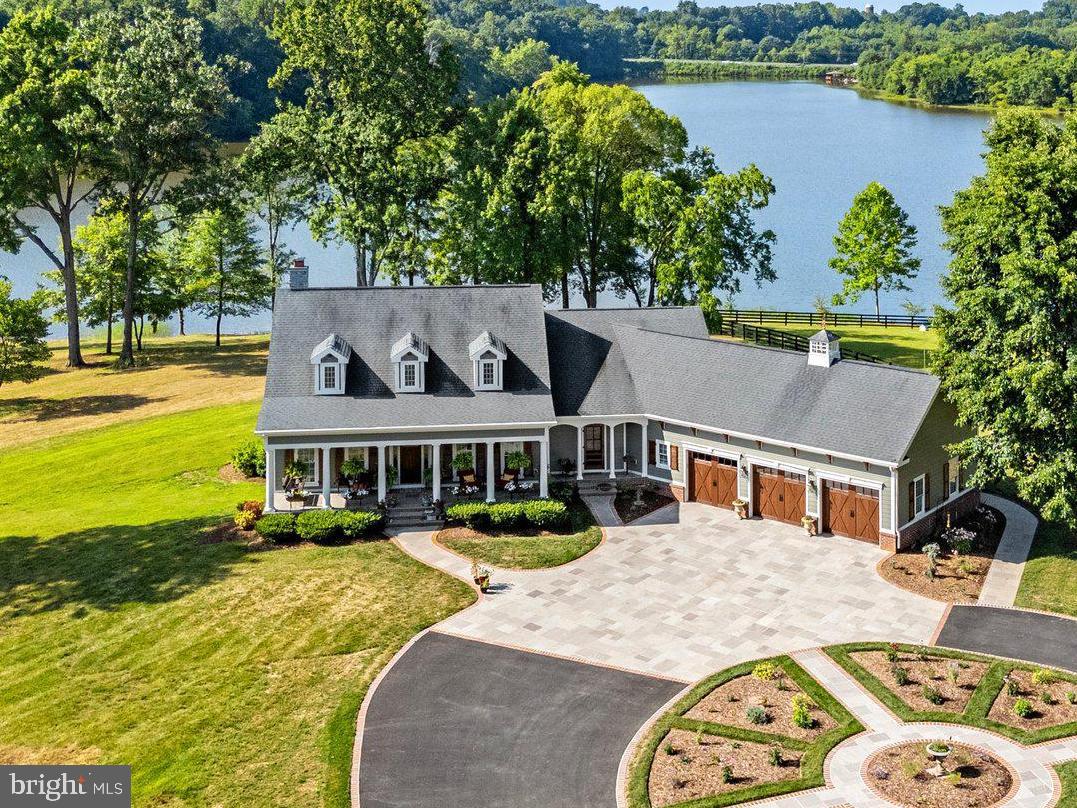 Nothing says "Home Sweet Home" quite like a Cape Cod, and this house simply overflows with upscale charm!    “Flent Cottage” is a hidden lakeside retreat providing all the elements of extraordinary country living, without sacrificing immediate access to the conveniences required for a busy lifestyle.   Seemingly right off the pages of Southern Living magazine, a breezy front porch invites you to relax, settle in and stay a while.   Thoughtful design & carefully selected details lend to the sense of sophistication, but this home was designed to be relaxing and comfortable.   Impressive moldings, rich woods, and trendy accents create elegant living spaces.  The floor plan flows easily and offers inspiring water views from almost every room in the house.  The kitchen was designed to function as beautifully as it looks, and is a well-loved place for impromptu gatherings, easily flowing over to the living room and the outdoor spaces.   The main level owner’s suite is a highlight of this home…it is a peaceful sanctuary, with ever-changing views of light glistening on the lake and access to the screened porch to enjoy fresh morning breezes.
Fantastic outdoor spaces offer a variety of places for casual dining and irresistible hours of stargazing, in almost any weather!     Gardeners will appreciate the variety of established plantings and well-organized potting shed.    Equestrians will adore the well-appointed stable, 4 board fenced paddocks, sand riding arena and easy access to an abundance of equestrian facilities and activities!   Avid anglers can simply stroll down to the private dock, hop in a boat and enjoy fishing 255 acres in Lake Culpeper, known for largemouth bass, channel catfish, blueg ill and crappie.     For those who must commute, it is easy to access Charlottesville, Fredericksburg or Northern Virginia.  Or, take a train to Union Station in DC.     You’ll never run out of reasons to love living in Culpeper.  Still known for its deep history, farming community and friendly, small-town charm, it was recently named “One of the Best Small Towns in Virginia” by Travel & Leisure.   Culpeper is full of surprises, starting with the interesting restaurants and boutique shops lining Davis Street.    Over $700k in recent upgrades & improvements make this home an excellent value!   For a glimpse of this extraordinary home, please ask for a complete brochure (and the  video), but to fully appreciate the scenery and the graciousness of “Flent Cottage”, you will surely want to schedule a private tour!