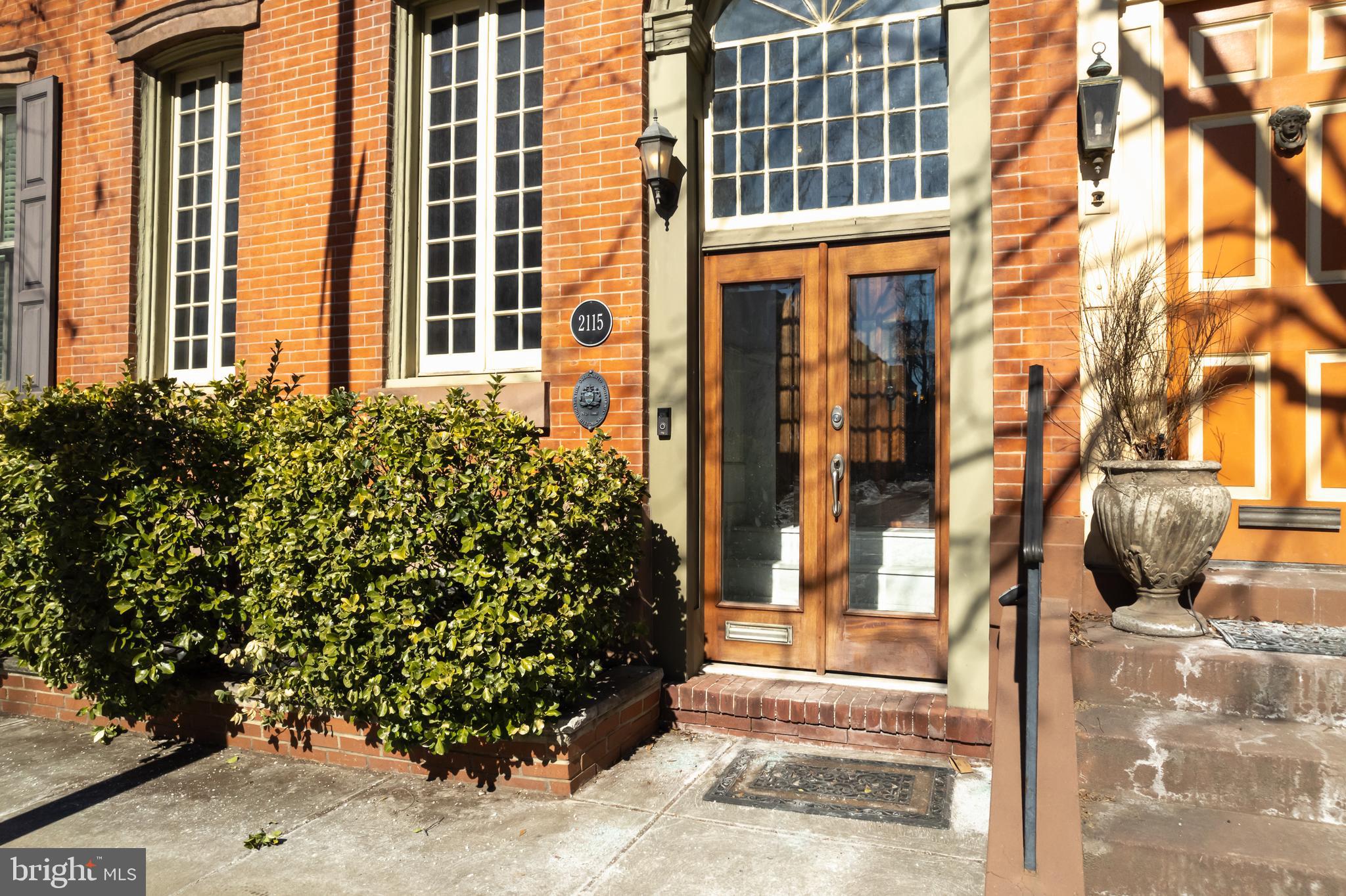 Circa 1860s architectural residence offering four levels of refined living plus a newly constructed roof deck with pergola completed in December 2025. One year of pre-paid garage parking is included.  Blending preserved historic craftsmanship with meaningful modern upgrades, this home delivers scale, character, and functionality in equal measure.  The main level unfolds from a formal foyer into a front parlor anchored by a fireplace, oversized windows, and detailed ceiling moldings. A formal dining room transitions to a sitting area and expansive chef’s kitchen with dedicated eating space. Large windows and three French doors create a seamless indoor-outdoor connection. A powder room, laundry room, and secondary staircase enhance everyday flow.  The second level showcases stained-glass details, inlaid oak flooring, substantial 2-inch solid wood doors, and original fireplaces. The primary suite features a fireplace, dual wardrobe closets, and a spa-style bath with soaking tub and multi-head shower.  Upper levels offer multiple en-suite bedrooms with strong proportions, oversized windows with open cross-street views toward Lombard Street, and flexible living arrangements.  The finished lower level provides recreation space, powder room, integrated media systems, extensive storage, and dual-zone HVAC.  A rare opportunity to own a residence defined by architectural substance, layered living, and enduring craftsmanship in one of Philadelphia’s most sought-after neighborhoods.