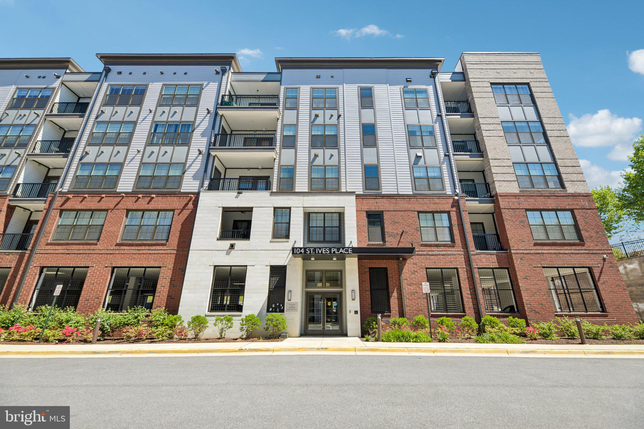 Welcome to 104 Saint Ives Place #402, an exceptional top-floor corner residence just moments from the vibrant waterfront at National Harbor, known for its premier dining, shopping, and entertainment. Freshly painted in a neutral color palette, the home feels bright, inviting, and truly move-in ready.  This modern, light-filled home offers 2 bedrooms, 2 bathrooms, and a versatile den, along with the rare advantage of a private electric vehicle (EV) charger in a secure garage, an increasingly valuable feature that enhances both daily convenience and long-term appeal for today’s buyers.

Inside, the thoughtfully designed open layout is enhanced by luxury vinyl plank flooring, recessed lighting, ceiling fans, and motorized window treatments, creating a clean, contemporary feel throughout. Freshly painted in a neutral color palette, the home feels bright, inviting, and truly move-in ready.The gourmet kitchen anchors the home with a large quartz island, shaker-style cabinetry, designer backsplash, and premium appliances including an oven, cooktop, and chimney-style hood—ideal for both everyday living and entertaining. The living and dining areas flow seamlessly to a private balcony with peaceful, tree-lined views, offering the perfect setting to unwind.

The spacious primary suite serves as a true retreat, complete with a custom walk-in closet and a spa-inspired bathroom featuring a double vanity and a tiled walk-in shower with built-in bench seating. Additional highlights include a dedicated EV charger assigned to the unit, secure garage parking with tandem space for two vehicles, key-fob building access, elevator service, a dedicated laundry room, and a conveniently located interior mailbox. Notably, this unit offers one of the lowest condo fees within the Flats, delivering exceptional value without compromising location.

Set within the Flats at the National Harbor, a gated, boutique-style community with controlled access and professional management, residents enjoy a low-maintenance lifestyle just steps from the waterfront and minutes from world-class destinations like MGM National Harbor (approximately 0.5 miles, about a 2-minute drive or 10-minute walk), National Harbor Waterfront (approximately 0.3 miles, about a 5-minute walk), and Old Town Alexandria (approximately 6 miles, about a 15-minute drive). Commuters will appreciate easy access to I-495 and I-295, placing Washington, D.C. roughly 10 miles away (about a 20–25 minute drive).

For those who value proximity to key D.C. destinations, you’re just minutes from Nationals Park (approximately 8 miles, about a 15–20 minute drive), the vibrant Navy Yard neighborhood (approximately 8 miles, about a 15–20 minute drive), and the iconic United States Capitol (approximately 9 miles, about a 18–25 minute drive).

Elegant, functional, and move-in ready, this is a rare opportunity to own a premium residence in one of the region’s most dynamic and sought-after destinations, where lifestyle, location, and long-term value come together seamlessly.