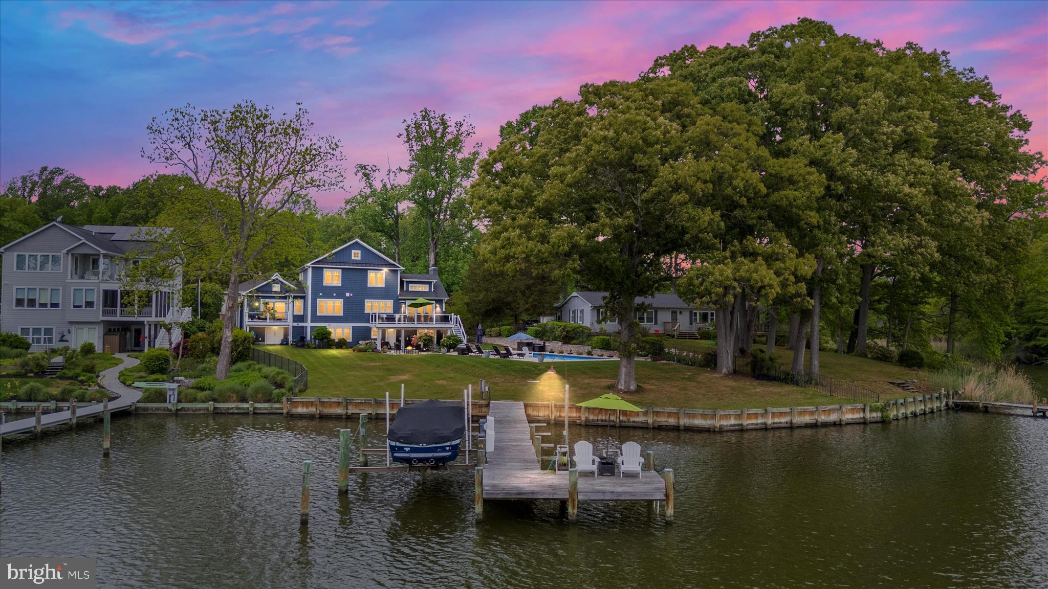 A rare opportunity to own an extraordinary waterfront retreat on Whitemarsh Creek, just moments from the Rhode River. With over 100 feet of shoreline and sweeping, unobstructed water views, this exceptional property captures the very best of Chesapeake Bay living.

Set on just over half an acre, this craftsman-style home was completely reimagined and rebuilt by a luxury custom builder in 2016, creating an eco-friendly residence where thoughtful design, quality craftsmanship, and breathtaking natural surroundings come together seamlessly.

Inside, the home offers over three beautifully finished levels with 5 bedrooms and 4.5 baths, designed to maximize comfort, functionality, and the stunning waterfront setting. The main level features engineered wide-plank hickory flooring, skylights that flood the home with natural light, vaulted ceilings, and a welcoming living room with a gas fireplace and expansive water views.

The chef’s kitchen is the heart of the home, featuring a massive center island, quartz countertops, GE Monogram appliances, a farmhouse sink, and exceptional space for entertaining and gathering.

The main-level primary suite provides a private sanctuary with two walk-in closets with custom organizers and a luxurious spa-inspired bath featuring dual vanities, a soaking tub, and a walk-in shower. Step outside to your private deck and take in peaceful water views to start or end your day.

Also on the main level is a spacious laundry and mudroom with built-in storage bench, cabinetry, utility sink, and an additional refrigerator—perfect for everyday living and waterfront entertaining.

Upstairs, three additional bedrooms with new carpet provide ample space for family and guests, including a fourth bedroom with its own walk-in closet and private en-suite bath.

The fully finished walk-out lower level with new carpet adds even more flexibility with a large family room featuring the home’s original wood-burning fireplace, a fifth bedroom, full bath, exercise nook, and bonus room. A separate exterior entrance to the lower-level bath offers convenient access from the pool area.

Outdoor living is equally impressive. The backyard is designed to take full advantage of the waterfront setting with a heated custom saltwater pool installed by Goudy Pools in 2024, complete with sun deck, patio, firepit area, and composite decking overlooking the water.

For boating enthusiasts, the rebuilt pier (2017) includes a 10,000 lb boat lift, swim platform, water and electric, and approximately 4 feet of mean low water—providing easy access to the Rhode River and beyond.

Additional features include a charming composite front porch, two-car garage with additional storage, and an in-ground irrigation system.

Meticulously maintained and thoughtfully designed, this home is truly a rare waterfront offering—where luxury, comfort, and the beauty of the Chesapeake lifestyle come together in one unforgettable setting.