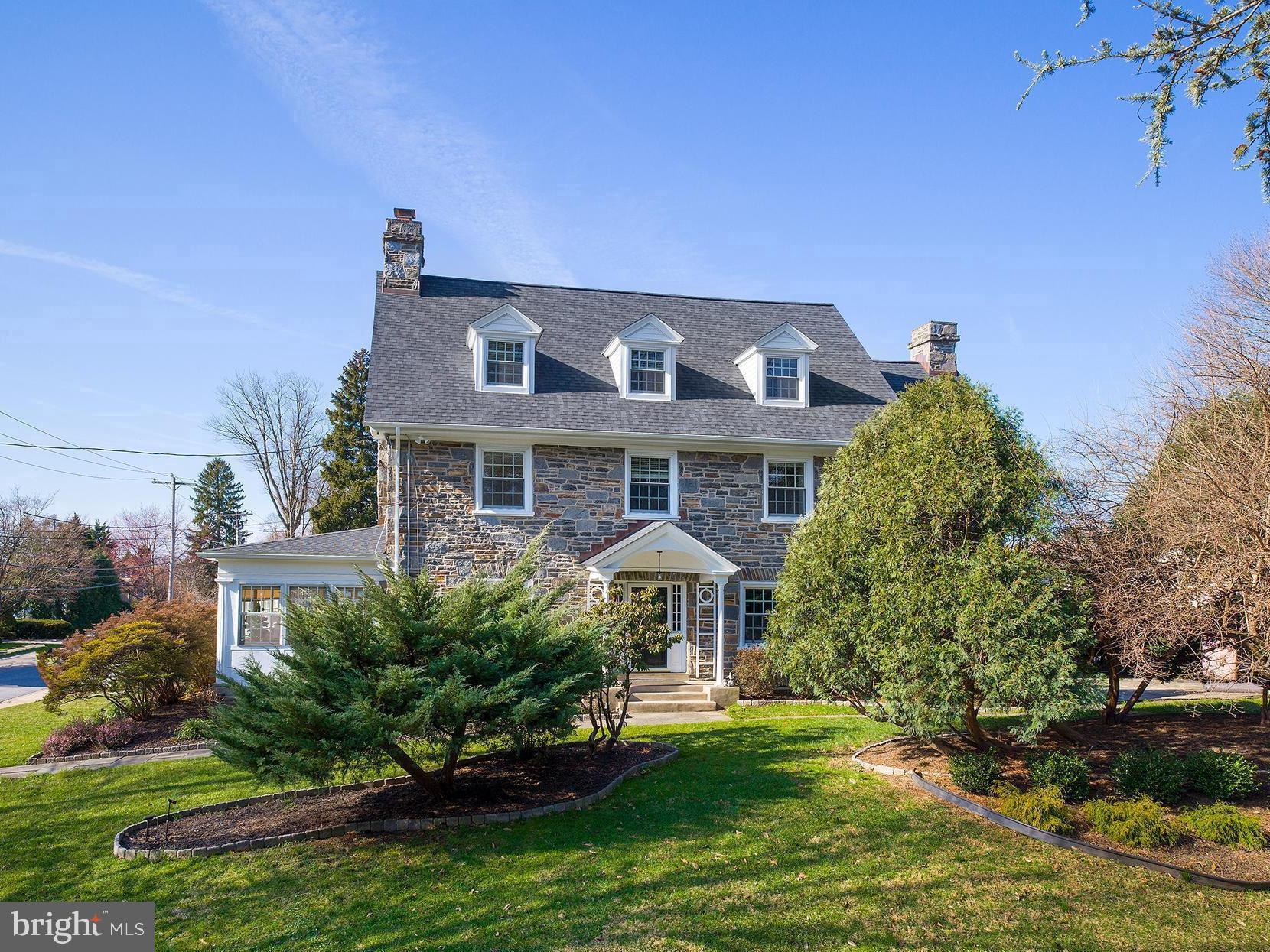 Welcome to 315 N Bowman Ave, Merion Station, where elegance and luxury converge in this exquisite Main Line masterpiece. Celebrating a century of grace, this quintessential center hall stone colonial home invites you to partake in a living legacy, offering a glorious blend of prestige and timeless beauty, nestled in one of the most distinguished neighborhoods.

The exterior of the home is equally captivating, with a long walkway leading from the sidewalk-lined Bowman Ave to a portico covering the step-up front entry, flanked by side lites on either side. The front of the home faces Linden Ln, enhancing its curb appeal and inviting guests with its stately presence.

Yard space extends to the right of the home and to the rear, providing ample outdoor space for recreation and relaxation. Hidden behind lush shrubs is a flagstone patio in the rear of the home, accessible from the mudroom and adjacent to the kitchen, offering a secluded retreat for outdoor dining and entertaining.

Step inside and experience the warmth and charm of this historic residence, where every detail reflects a bygone era of craftsmanship and elegance. As you enter the living room, you're greeted by the warmth of a gas fireplace featuring a stone surround, a majestic haven for relaxation. Glass double doors on either side of the fireplace lead to the enclosed sun porch, offering a tranquil space bathed in natural light. Exposed stone and windows on three sides create a serene ambiance, while classic "shutter" wooden doors add a touch of timeless elegance.

Continuing through the first-floor hallway, you'll find a door to the renovated kitchen, as functional as it is beautiful, boasting stunning stainless steel appliances, white shaker cabinetry with dark hardware, and white countertops. Adjacent to the kitchen is a mudroom/breakfast area, providing access to the flagstone terrace hidden behind shrubs, offering a secluded retreat for al fresco dining. The first-floor powder room adds convenience to this level.

Ascend to the second floor, where you'll discover the luxurious primary suite, divided into two sections, providing a serene escape. Its two walk-in closets offer ample storage, while the adjoining primary bathroom was renovated to exude modern luxury with its glass-enclosed shower, new vanity, and tile flooring. Two additional bedrooms on this floor offer their own unique charm. One bedroom features two built-in bookcases and a built-in desk between, while the other exudes warmth with a wood-burning fireplace and brick surround.

Venture to the third floor, where additional living space awaits. Four bedrooms offer versatility and comfort, with one currently used as an office and another as a music/hi-fi room. A renovated hall bathroom completes this floor, ensuring modern comfort for the entire household.

The fully finished lower level, transformed into a media room, provides endless entertainment possibilities. New carpet throughout and freshly painted walls create a welcoming atmosphere. The lower level powder room offers additional convenience. Two unfinished portions provide ample storage space, ensuring organization and functionality for daily living.

With its seamless blend of historic charm and modern amenities, this residence is ready to offer the ultimate Main Line lifestyle for the next generation, ready to be enjoyed by its next fortunate owner. Enjoy a convenient walk to shops, restaurants, houses of worship, effortless commutes via the nearby Merion train station and bus stop, and close proximity to the award-winning Merion Elementary School.