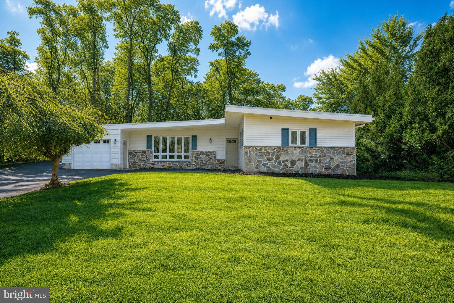 New well now installed.  Tucked away in a quiet residential pocket of West Chester, 904 S Chester Road is an exciting opportunity to own a truly special home that perfectly blends style, comfort, and location! This gorgeous, completely renovated 4 bedroom, 2 full bathroom  ranch-style mid-century home with attached garage is filled with eye-catching design! A striking exterior features updated siding, classic stone accents, and an iconic sloped midcentury roofline. Set on a nice, usable lot, the home also boasts a rebuilt deck that invites you to relax, entertain, and enjoy the outdoors. In addition, the oversized attached garage can fit two cars back to back, allowing for plenty of hobby or storage space. Inside, you’ll love the bright and airy open-concept living, dining, and kitchen space, where large windows flood the home with natural light and a beautifully restored double-sided stone fireplace creates a stunning focal point. The brand-new kitchen is truly the heart of the home, showcasing attractive wood-toned cabinetry, stainless steel appliances, and quartz countertops. A center island offers generous workspace and flexible dining options. An additional separate room off the main living areas provides the perfect spot for a playroom, home office, or versatile flex space. The bedroom wing features four comfortable bedrooms, including a beautiful primary suite with a private bathroom and walk-in shower. A second full bathroom serves the remaining bedrooms with a tiled tub/shower combination. Convenient main-floor laundry adds everyday ease, and the thoughtful renovation throughout makes this home completely move-in ready. A brand new rubber roof and new, efficient electric heat pump will keep you warm and dry this winter. With its standout midcentury style, functional layout, and desirable West Chester setting, this home is an absolute must-see!