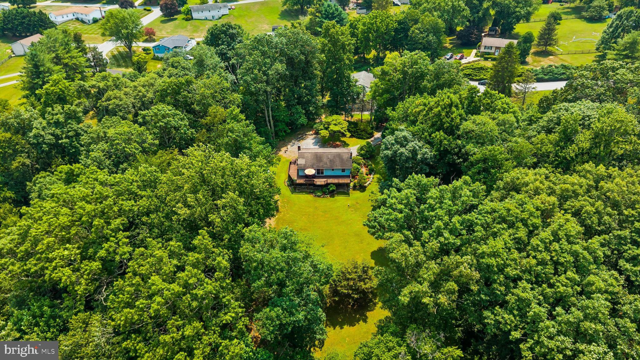 Tucked away at the end of a quiet cul-de-sac in sought-after Finksburg, this cherished, immaculately maintained rancher strikes the perfect blend of privacy, modern updates, and everyday convenience on 1.35 scenic acres. A tree-lined driveway welcomes you to a peaceful setting surrounded by mature, healthy trees, with a gently flowing stream at the rear of the property creating your own private retreat. This home offers a perfect balance of tranquility and convenient accessibility, situated just minutes from Westminster, Route 140, shopping, dining, schools, parks, and major commuter routes.

Offering over 2,000 square feet of finished living space, this thoughtfully updated home combines the convenience of main-level living with flexible spaces. The main level features three bedrooms, including a comfortable primary suite with two closets and an updated private bath. New luxury vinyl plank flooring extends throughout all three bedrooms, while beautifully updated bathrooms add a fresh, modern feel. The inviting living room showcases soaring cathedral ceilings, stunning herringbone hardwood flooring, and a dramatic floor-to-ceiling natural stone accent wall with a stone hearth ready for a wood stove. The spacious eat-in kitchen is ideal for both everyday living and entertaining, offering cathedral ceilings, abundant cabinet space, an oversized pantry, newer stainless steel appliances, and sliding doors leading to the expansive wraparound deck overlooking the private backyard.

The walkout basement extends the living space, offering exceptional versatility with a spacious family room centered around a second striking natural stone accent wall and a cozy wood stove with a brick hearth. An additional finished flex room is perfect for a home office, guest room, fitness area, hobby space, or playroom. The laundry room and bathroom are both brightened by beautiful tile work. 
Step outside and enjoy your own outdoor oasis. The expansive wraparound deck overlooks a generous backyard with mature landscaping, open green space, and a picturesque stream, creating the perfect setting for entertaining, gardening, relaxing, or simply enjoying nature year-round.

Significant recent improvements provide added value and peace of mind, including a new water heater, water softener, neutralizer, and well pressure tank (2022), upgraded septic piping (2023), Ethernet wiring to two bedrooms (2023), newer stainless steel kitchen appliances (Dec. 2023), updated bathrooms (2022), new luxury vinyl plank flooring throughout the bedrooms (2022), new LG washer and dryer (2022), and new sliding doors in the basement (2022). Additional highlights include a 40-year architectural shingle roof with a transferable warranty, a radon mitigation system, and an oversized storage shed.

If you've been searching for a move-in ready home in Carroll County that offers main-level living, a finished walkout basement, abundant outdoor living space, and the rare combination of privacy, character, and convenience, this exceptional Finksburg property is one you won't want to miss.