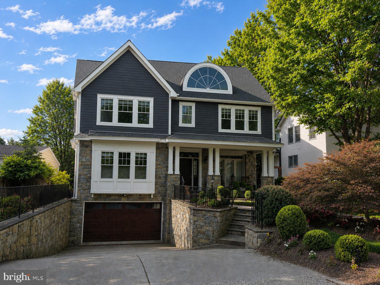 Welcome to 5114 Wessling Lane, nestled in the highly sought-after Bradley Hills neighborhood, this exceptional stone-front residence offers four finished levels, an elevator, 6 bedrooms, 5.5 bathrooms, and more than 6,500 square feet of beautifully designed living space. Combining timeless craftsmanship with modern luxury, this home is thoughtfully appointed for both elegant entertaining and comfortable everyday living.
A flagstone front walk and inviting covered porch with a wainscoted ceiling create a warm first impression. Inside, an impressive wide foyer welcomes you to a home featuring hardwood floors, plantation shutters, extensive wainscoting, crown molding, recessed lighting, tray ceilings, and graceful arched entryways throughout the main level.
The main level includes a sophisticated living room with a fireplace and mantel, a private executive office with glass pocket doors, custom built-ins, tray ceiling, large closet, and French doors opening to the front porch. A banquet-sized dining room provides the perfect setting for formal gatherings, while the spacious family room features a striking stone gas fireplace, custom built-ins, and French doors leading to the outdoor living spaces.
The gourmet chef’s kitchen is a standout, boasting travertine stone flooring, granite countertops, an oversized center island with prep sink, instant hot water, Viking six-burner gas cooktop, double wall ovens, built-in microwave, oversized refrigerator, two dishwashers, pantry with roll-out shelving, built-in desk area and abundant cabinetry. The adjoining breakfast area features dramatic quad French sliders opening to the screened porch. A granite butler’s pantry with beverage refrigerator provides seamless access between the kitchen and family room.
Outdoor living is equally impressive with a recently updated screened porch featuring a ceiling fan, heater, and TV wiring. The expansive Trex deck includes a pergola, built-in gas firepit, outdoor grill with storage, and overlooks the fully fenced backyard.
Upstairs, the luxurious primary suite serves as a private retreat with a tray ceiling, separate sitting room with pocket doors, quad French doors opening to a private deck, dual custom walk-in closets, and a built-in makeup vanity. The spa-inspired primary bath offers a jetted soaking tub, oversized steam shower with dual shower heads and bench seating, dual granite vanities, stone tile flooring, and additional storage. Three additional oversized bedrooms, two full bathrooms, and a well-equipped laundry room with sink and extensive cabinetry complete this level.
The fourth level provides exceptional flexibility with a spacious living area, large bedroom, full bath, and additional storage—ideal for guests, an au pair suite, or a private retreat.
The walkout lower level features a large recreation room with laminate flooring, an additional bedroom with walk-in closet, full bathroom, multiple storage closets, utility room, and direct access to the backyard.
Additional highlights include:
•