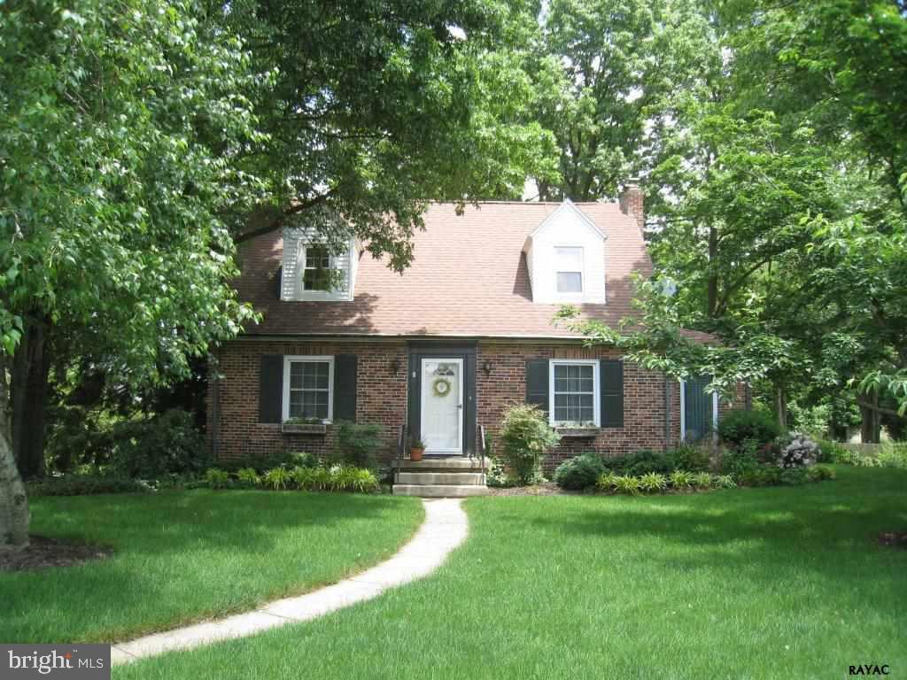 In a park-like setting & filled w/ character & charm, this 3BR, 2.5BA has wood flrs, LR w/ gas FP, updated KIT & baths, Sunroom w/ brick walls, large LL FR w/ stone  FP  & pellet stove, spacious LAU room.  You'll enjoy the lush greenery, patios, pond & treed privacy.
