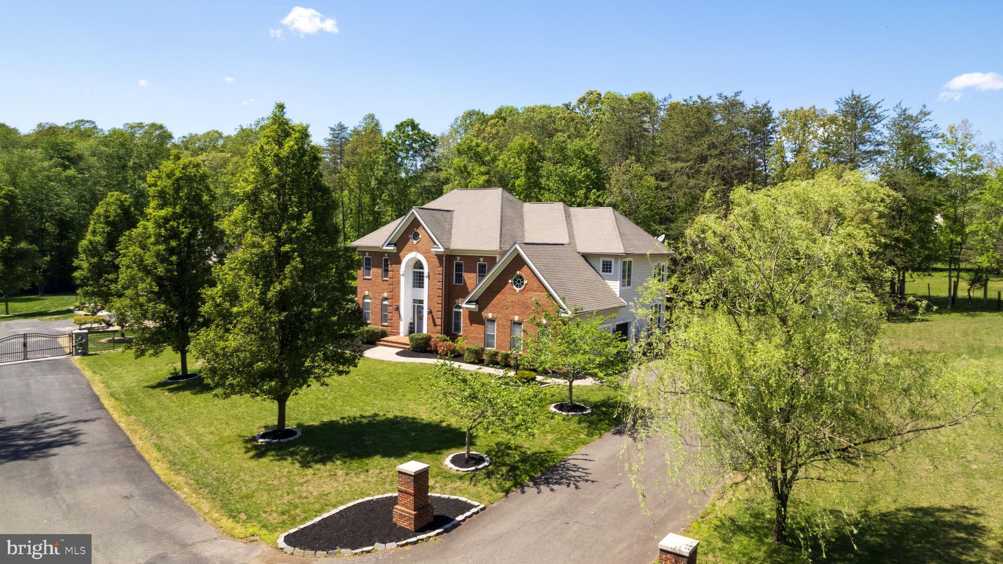 Marshall / Benton / Colgan Pyramid. Picture Perfect 6,539 finished sq ft | 5 BR | 4.5 BA custom-built brick and HardiePlank Colonial w/ massive 3-car garage. Situated on a FLAT one-acre lot (see PLAT as private lot extends across private road) down a dead end, private enclave with no HOA on public water / public sewer, this tastefully-designed space blends luxury with modern comfort of indoor/outdoor living.  The main level opens into a 2-story Foyer and features an open floor plan highlighted by a truly exemplary Chef-inspired Kitchen (2021 renovation) leading into a dramatic, 2-story Great Room with gas fireplace, custom coffered ceiling and direct access to the park-like outdoor hardscape and fully-fenced yard.  Speaking of yard, the backyard backs to open pasture green space and the property includes added land across the private road along with a massive front yard and grand driveway. 

Rich hardwoods blend each space on the main level, which also includes a dedicated home office with 8-foot French Doors, a separate Dining Room, and open Living Room flanked by windows w/ plantation shutters. Design touches like wainscoting wall panels, columns, and expansive crown moulding integrate with the high-end interior paint and are showcased w/ added depth by the natural light on walls of windows surrounding each room.

Focal points of the Kitchen start with an abundance of Charleston-styled cabinets that wrap through a Butler's Pantry to the Dining Room. In addition to the centerpiece island, the Kitchen comes complete with a showpiece Range Hood, leathered granite countertops, extensive marble subway tile backsplashes, designer lighting, double ovens, and a luxury WOLF gas cooktop situated under a pot filler. Try not to get lost in the walk-in Pantry for plentiful dry storage and enjoy coffee from the adjacent Breakfast Room.

The Upper Level is designed with thoughtful functionality, starting with a Primary bedroom w/ tray ceiling that includes a 3-sided gas fireplace bisecting the sleeping area from the ensuite Sitting Room. Closet Space? Try 3 walk-ins, including a dedicated closet "room" that is larger than most bedrooms. The primary bath gives Four Seasons vibes  starting w/ the heated tile floors and featuring a massive seamless glass walk-in shower w/ dual rain heads and stone soaking tub, Three additional bedrooms each have their own personality, including a bedroom with it's own ensuite bathroom fully-renovated in 2025 with a sleek barn door and finishes. Bedrooms 3 and 4 have plenty of space to spread out and share a full Jack-and-Jill bathroom. Modern touches even extend to the upstairs laundry room, which includes an upgraded sink and a dryer vent booster fan (2025 upgrade).

A versatile, walkout Lower-Level w/ separate entrance hosts the 5th bedroom with a walk-in closet next to the 4th full bathroom. The Rec Room includes a 3rd gas fireplace and wet bar with wine storage - while leading to the epicenter of at-home entertainment private Home Theater. The design brings the cinema to you with elegant mood lighting, surround sound, and eight theater chairs on a cascading raised platform complete with state-of-the-art projector and screen. Snacks? The built-in wet bar and refrigerator will cater to your guests.  How about storage? Enjoy access to one of the largest storage rooms you'll see in the area inside the house + a separate Storage Shed outside in the backyard that comes with its own snowblower for those winter storms.

Additional upgrades include a Central Vacuum system, replacing the 2 HVAC zones (approximately 3 years old), dual sump pumps with battery backup (approximately 3 years old), a whole-home filtration system, and a brand new (2026) tankless water heater for instant and endless hot water.

And just in time for Summer...a nicely-appointed outdoor Kitchen-area built into the patio can be customized for whatever propane grilling, meat smoking, or flat top Blackstone cooking you desire.