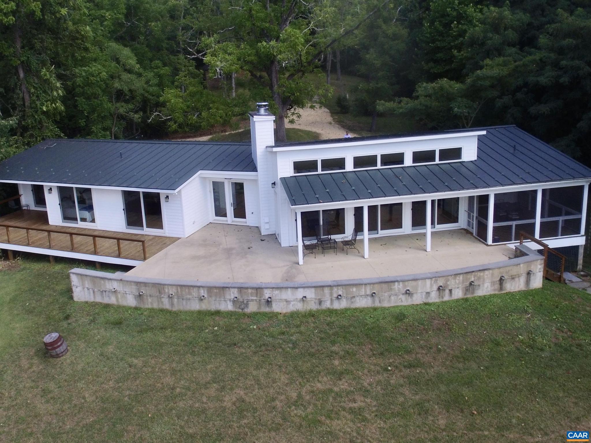 A private, modern home with a tiny, quaint fieldstone studio/office/guest cottage in Ivy only 15 minutes from Charlottesville and the University of Virginia. 206 acres rising over the crest of Taylors Mountain at 1,440 feet in elevation. The residence is designed for maximum natural light and the enjoyment of the Blue Ridge Mountain views, with high vaulted 13 foot ceilings and large windows. One level living at a grand scale with large and spacious rooms. The finished living space is complemented by expansive outdoor covered porches, a terrace and a fabulous screened-in porch. This 2-bedroom house was designed as a three bedroom home, but one bedroom was opened up to serve as a family room instead. Large gas fireplace, hardwood floors and a generous hallway are just a few features. The unfinished basement could serve as a great workshop with ample storage. Extensive trail system and old logging roads to the top knob of Taylors Mountain and waterfall. Fenced paddocks for horses, other livestock and farm animals. Elevated pasture behind the house is well-suited for a small vineyard at 725 feet. Truly a private domain yet so close to Charlottesville.,Glass Front Cabinets,Granite Counter,White Cabinets,Fireplace in Living Room