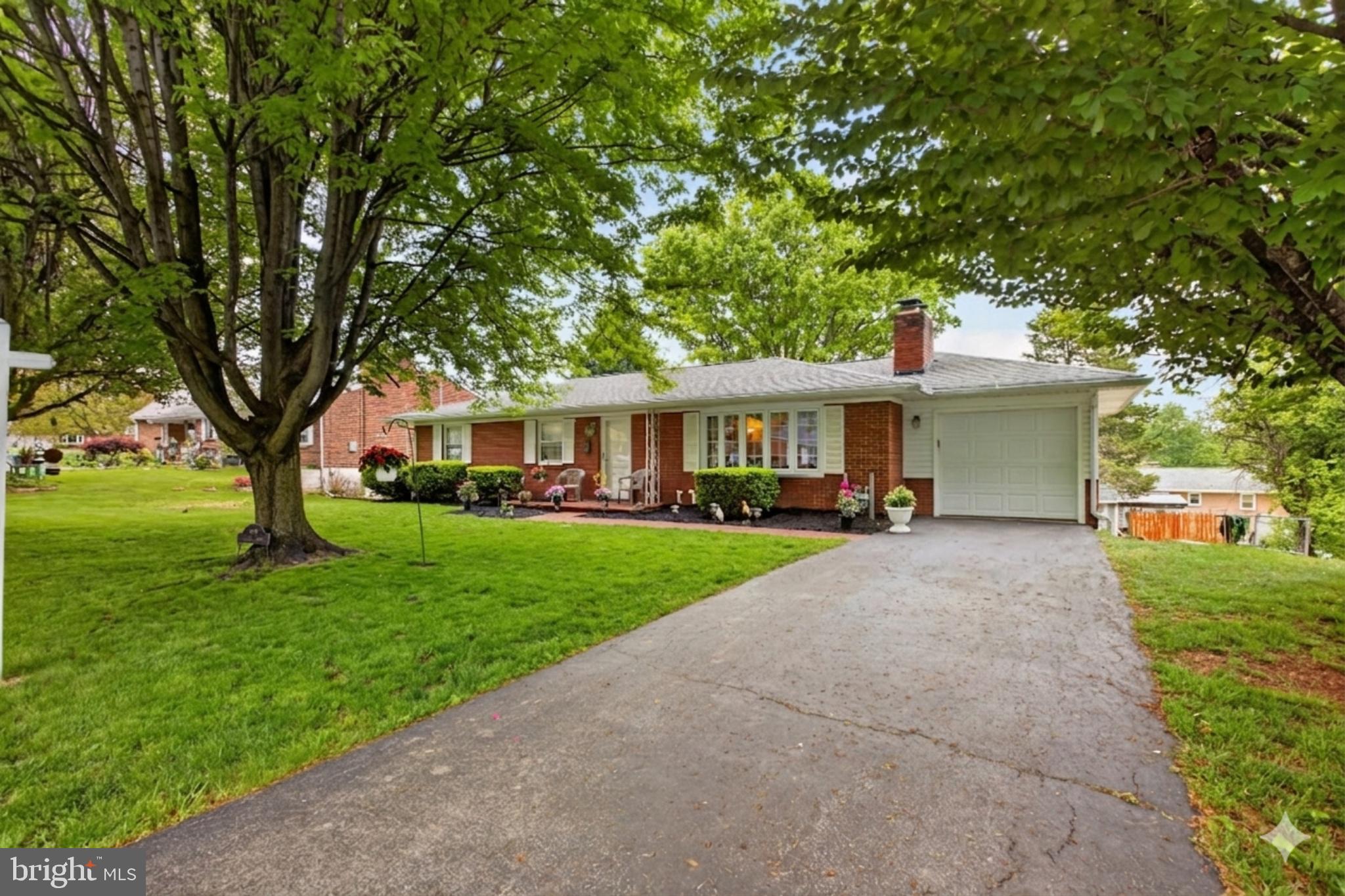 Classic brick rancher with a spacious layout, solid construction, and a sunroom filled with natural light—this home offers comfort, flexibility, and opportunity from day one. The main level features a large living room anchored by a wood-burning fireplace, flowing seamlessly into a dedicated dining area and kitchen. The kitchen provides ample cabinet storage and workspace, with room to update finishes and make it your own. Just off the main living area, the standout sunroom features cathedral ceilings and walls of windows, creating a bright and inviting space overlooking the backyard. Enjoy year-round use with its own dedicated heating and cooling—separate in-unit A/C and baseboard heat. Step directly from the sunroom onto a covered deck, perfect for morning coffee, relaxing evenings, or entertaining guests. Down the hall, you’ll find well-sized bedrooms along with 1.5 baths, all in very good condition and ready for your personal touch over time. The finished walkout basement adds a full second living area, complete with a rec room, pool table space, built-in bar, and direct outdoor access. There’s also unfinished space ideal for storage, a workshop, or future expansion, plus a dedicated laundry area. Outside, enjoy a large yard with mature trees, a covered patio area, and plenty of room to entertain, garden, or unwind. The walkout design enhances indoor-outdoor flow, and two storage sheds provide additional space for tools, equipment, or hobbies. Conveniently located near W Church St, Virginia Ave, I-81, and Route 40, with easy access to shopping, dining, and everyday essentials. Nearby parks offer additional outdoor enjoyment!