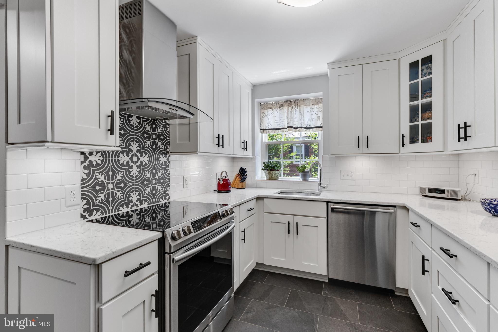 Beautiful 1-bedroom, 2-bathroom Hermitage model home nestled in sought-after Fairlington Villages! Boasting just over 1,500 square feet across two living levels, this spacious residence combines timeless charm with modern updates throughout. The bright & inviting upper level features original hardwood flooring throughout the spacious living room, dining area, hallway, & bedroom. The dining area is accented by a stylish oversized pendant light & French door access to the covered balcony & private paver patio - the perfect spot to enjoy your morning coffee or unwind at the end of the day.  The renovated kitchen offers both style & functionality with oversized gray tile flooring, white soft-close cabinetry with modern black hardware, custom pull-out shelving, under-cabinet lighting, quartz countertops, stainless steel appliances, & a classic white subway tile backsplash with decorative accent tile behind the stove/range hood. Down the hall, you'll find a convenient closet complete with Elfa shelving for exceptional organization. The spacious bedroom features a modern white ceiling fan, charming wooden shutters, & a large two-door closet with additional Elfa shelving. The beautifully renovated upper-level bathroom showcases basketweave tile flooring, an updated vanity, & a white subway tile shower with a built-in bench, hexagon tile flooring, niche shelving, rainfall showerhead, & a large window that fills the space with natural light.

The finished lower level expands the home's living space with updated LVP flooring throughout the spacious recreation room, complete with a closet, built-in bookcase, & separate entrance to the building hallway. The bonus room offers built-in cabinetry, shelving, & desk space - ideal for a home office, hobby room, & additional storage. The renovated full bathroom features basketweave tile flooring, an updated vanity, & a sliding glass door shower with a white subway tile surround, black hexagon tile flooring, & niche shelving. A separate utility/laundry room provides additional storage along with a full-sized washer & dryer. Home comes with two reserved/unassigned parking spaces. Fairlington Villages residents enjoy six pools, lighted tennis courts, tot lots/playgrounds, walking paths, and MORE! Ideally located near I-395 and the shops & restaurants at The Village at Shirlington, West Alex, Baileys Crossroads, Del Ray, & Old Town.