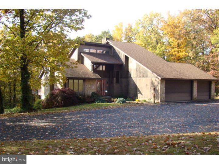 Contemporary home privately situated on 6+ acres with magnificent views. High impact as you enter the grand family room with dramatic 2-story stone fireplace and panoramic property views. Main level has 2 BR, kitchen/dining area and access to glass paneled 2-story all season room and wrap around deck. Up the open staircase leads to sitting/den area and two addt'l bedrooms including the serene master suite. Let your imagination run wild with lower level theater area, bar and gym. Amenities include efficient geothermal heat/cooling, 3-car heated garage, security sys., central vac and much more.