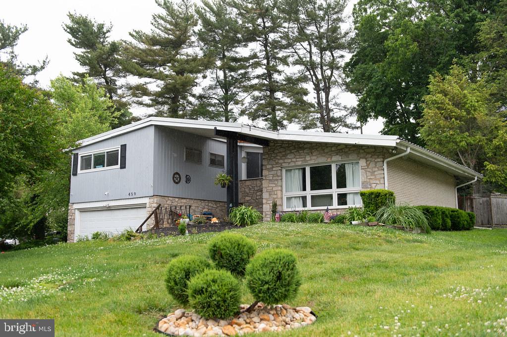 Welcome to 459 Harrison Avenue, a beautiful mid-century modern home in desirable Glenside. This home features three bedrooms, 2 full bathrooms and one powder room set on beautiful, well-maintained, quiet corner property. Walk in through the foyer, hang your coat in the large coat closet and have a seat in your beautifully expansive living room, filled with light from the front and back of the house. Walk through the dining room and get ready to cook in your beautifully renovated kitchen, complete with granite countertops, a double oven and a ton of cabinet space. Then, go relax by the wood-burning fireplace in the lower-level family room, which includes built-in shelving and cabinets, and a powder room. At the end of the day, unwind in your spacious master bedroom, complete with 2 large closets and an en suite bathroom. With a garage, an attic and an expansive laundry/utility room, you won’t have to worry about space for storage. Start your day with coffee on the front porch overlooking your beautiful garden, and end it with dinner on the back deck in your lush, fenced back yard. A great home to entertain in during any season, or to just relax at the end of a long day. Don’t worry about the roof (40 year metal roof installed in 2014), HVAC (new heater installed in 2022) or hot water (new water heater installed this year)! Walking distance to shops, cafes, the Glenside regional rail station (25 minute ride into Center City!), close to 309 and the PA Turnpike, and just down the street from the well regarded Glenside Elementary School and playground, this house is convenient to everything. Come and see all that 459 Harrison Avenue has to offer!