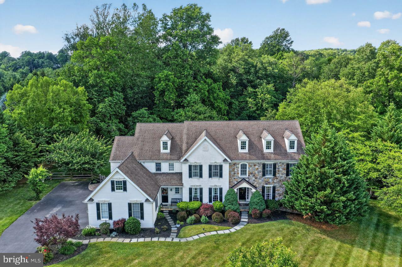Welcome to Chantilly Farm — an exclusive, private enclave of just 34 custom-built luxury homes in the heart of Chester Springs. This custom Moser-built residence delivers the privacy and scale buyers in this market spend years searching for, anchored by a stunning three-year-old in-ground saltwater pool and a sweeping stamped concrete patio.

From the moment you arrive, the presence of this home is undeniable. Enter through double doors into a two-story foyer, where a sweeping staircase makes an immediate impression. The formal living room and graciously proportioned dining room are made for holiday gatherings and milestone celebrations.

At the heart of the home, a gourmet kitchen impresses with a massive granite center island, off white cabinetry, and premium appliances. It opens seamlessly into a vaulted-ceiling family room featuring exposed wood beams and a dramatic floor-to-ceiling brick fireplace — the kind of space that naturally becomes the center of your daily life. A handsome study offers a quiet retreat for focused work or reading. Two stylish powder rooms and a large mudroom with garage access complete a main level designed for both beauty and function.

Step through sliding doors onto the patio and into your own private outdoor sanctuary. The Anthony Sylvan saltwater pool anchors a backyard defined by exceptional privacy and lush, rolling surroundings. Imagine summer evenings here. You will not want to leave.

Upstairs, the primary suite with is a true retreat, featuring  plantation shutters, a dedicated dressing area, custom built-ins, and a spa-inspired bath with a soaking tub, oversized shower and dual vanities. A princess suite with its own en-suite bath, two additional bedrooms sharing a Jack-and-Jill bathroom, a fifth bedroom, and a large laundry room complete the upper level with generous, thoughtful proportions throughout.

The fully finished basement raises the bar further. A custom wet bar with built-in appliances centers a spacious lounge made for Eagles Sundays and Phillies playoff runs. A powder room adds convenience for guests and entertaining. A flexible bonus room serves equally well as a home gym, studio, or second study. Bilco doors open directly to the backyard for seamless pool access. A sizable unfinished area provides abundant storage

The four-car garage features epoxy flooring and handles vehicles, outdoor gear, and more without blinking. Additional highlights include a recently updated HVAC system, a newer hot water heater, plantation shutters, and an electronic pet fence — the hallmarks of a home maintained with genuine care.

Set within the award-winning Downingtown Area School District, home to the nationally recognized STEM Academy, with easy access to the Montgomery School, the PA Turnpike, Route 30, Route 202, Marsh Creek State Park, Bryn Coed Preserve, and the rolling hills and open spaces Chester Springs is known for — this is the best of the Philly Suburbs. As an added benefit, HOA includes annual septic inspections, helping simplify routine maintenance and giving homeowners added peace of mind. 1704 Chantilly Lane delivers 5 bedrooms, 3 full baths & 3 half baths. and a lifestyle that's simply difficult to replicate.

Approximately 4,910 sq ft above grade, plus an estimated 1,500+ sq ft of finished living space below grade (buyer to verify). The beauty and privacy of this property must be experienced in person — schedule your private tour today.