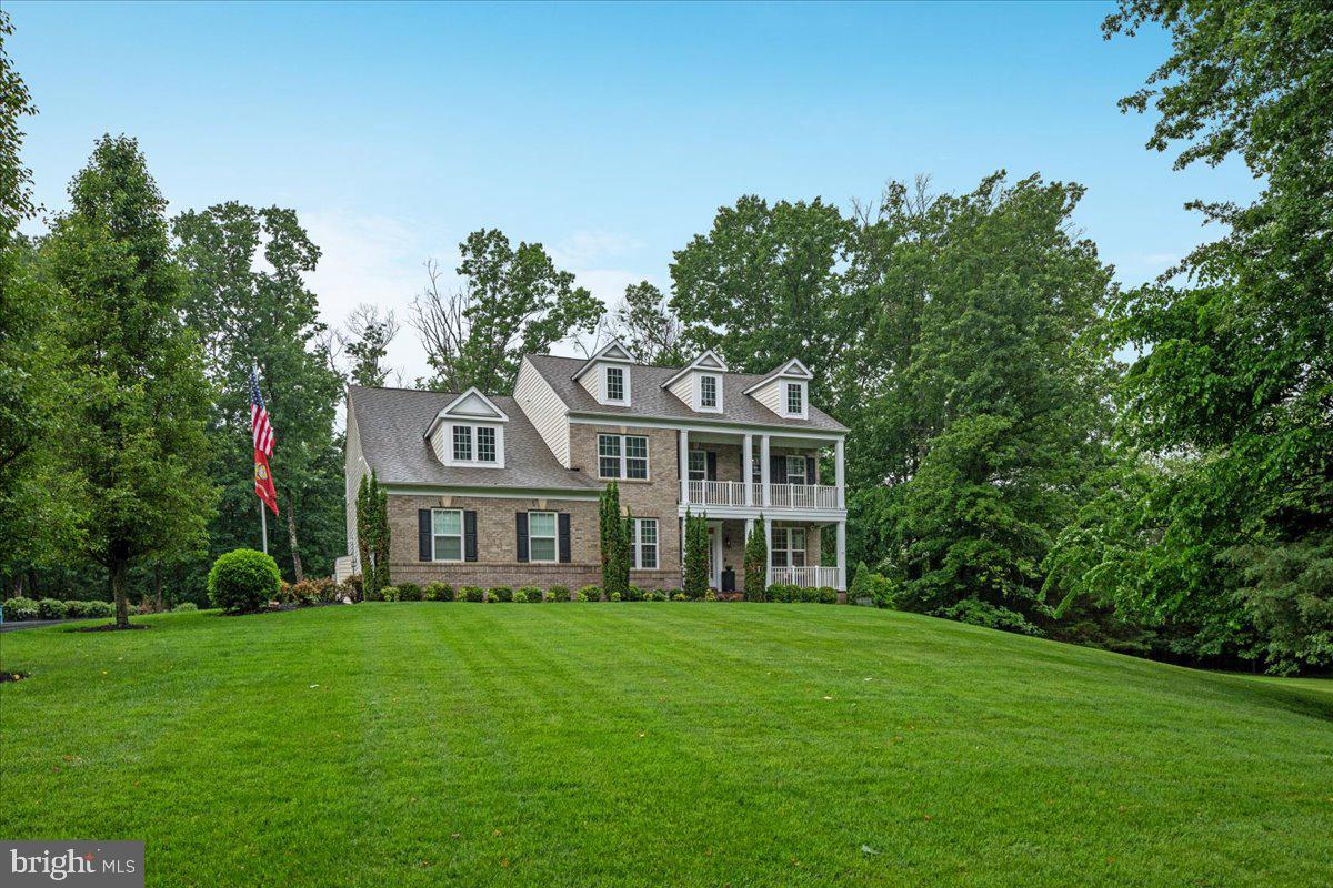 This exquisite Colonial-style home with its classic and stately presence is nestled on a beautifully landscaped, over 4 acres of wooded privacy offering a harmonious blend of luxury and comfort, perfect for those seeking a slightly rural lifestyle with a gentle touch of modern living in the exclusive and sought-after community of Huntleigh in Creighton Farms. This exceptional 5-bedroom, 4.5 bath custom estate offers over 6000 sq. ft of modern luxury living space with over $400K in premium upgrades.  This home features a symmetrical design with its front façade anchored by a covered porch with white columns that extend across part of the house, giving it a traditional and welcome look. Above, a second-story balcony that mirrors the porch below, adding both charm and architectural interest to this stunning home. The main level showcases a welcoming open grand entry with a rich and oak stained handrail and white spindles contrasting nicely against the darker wood steps. Straight ahead, a gorgeous gourmet kitchen featuring high end custom cabinetry, upgraded countertops, the heart of this home boasts a brand-new Wolf cooktop, double ovens, microwave, dishwasher, and oversized entertainment’s island along with a coffee/wine bar and lots of counter space making it ideal for your everyday living and entertainment on a grand scale. Flanked by a huge walk-in pantry and a mud room. Beautiful dark Engineered hardwood floors predominantly throughout, where you will find a warm and sun filled sunroom overlooking a private estate and mature trees. Entertain in the elegant dining room adorned with crown and chair rail molding, or gather in the formal living room for intimate moments The bright main-level office provides productive work-from home. Upper level, the primary suite has a beautiful chandelier, a stunning sitting room and a spa like bath with tub, shower complete with His/Her vanities, and an oversized walk-in closet. Two full baths with a shower and tub with Kohler fixtures. The finished lower level features a 5th bedroom with en suite with full bath, a game room, multiple areas for your own creation and two storage spaces. The walk-up basement provides a retreat featuring an extensive custom patio, fire pit and built-in grill, a 6 zones underground irrigation system and professional landscape lighting with a private alcove for relaxation and/or entertainment. The crown jewel at Creighton Farms is the 18-hole Jack Nicklaus championship golf course that you can join with additional membership. The expanded driveway leads to three car garage doors and 8 additional parking spaces. Situated on over a private 4-acre lot surrounded by nature, well-manicured walking trails, panoramic views of the gently rolling countryside, a serene creek, this one-of a-kind property feels tucked away yet remains conveniently close to the airport, railway, shopping, dining, and the Dulles Toll Road. Welcome Home!