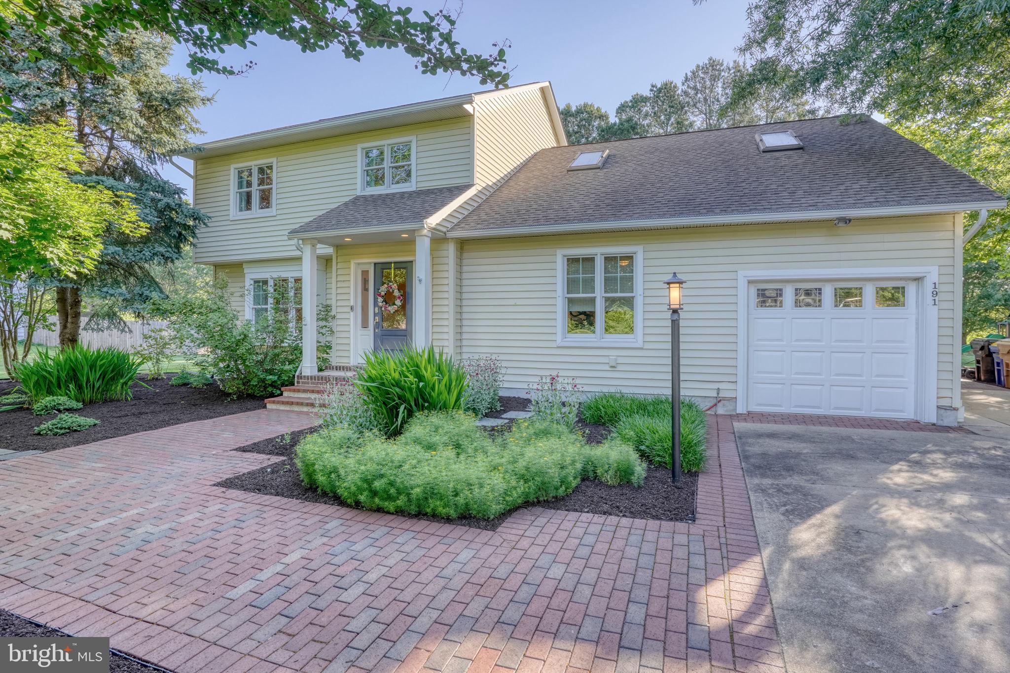 Welcome to this stunning two-story home, meticulously maintained and thoughtfully updated to create a truly one-of-a-kind living experience. Originally designed with a traditional floor plan, this residence has been beautifully transformed with an emphasis on comfort, functionality, and timeless style. From the moment you step into the inviting foyer, you'll appreciate the pride of ownership and attention to detail that is evident throughout. The first floor showcases an abundance of rich hardwood flooring, a formal living room, and an elegant dining room, all flowing seamlessly into the heart of the home. The chef's kitchen features stainless steel appliances, a stylish tile backsplash, breakfast bar seating, and ample workspace, making it ideal for both everyday living and entertaining. Adjacent to the kitchen is the spectacular great room, highlighted by soaring cathedral ceilings, exposed beam accents, and a freestanding wood stove with an impressive hearth that creates a warm and welcoming gathering space. A spacious laundry and mud room offers additional cabinetry, workspace, and storage, while numerous closets throughout the home ensure everything has its place. Upstairs, the light-filled primary suite provides a peaceful retreat complete with large closets and a private bath featuring a beautifully tiled shower. Three additional bedrooms, a full bath, and an expansive loft area offer endless flexibility for a home office, playroom, media room, or additional living space. Step outside and prepare to be captivated by the extraordinary outdoor living environment. The meticulously landscaped grounds are a showcase of color and texture, featuring an array of native perennials including blueberries, black raspberries, Black-Eyed Susans, and much more. Whether relaxing on the expansive brick patio or enjoying the tranquil water views beyond, this remarkable property comes alive in every season and offers a setting that is truly unforgettable. Additional upgrades include an energy-efficient geothermal HVAC system, irrigation system, Andersen 400 Series Low-E windows, and operable skylights that fill the home with natural light. Combining thoughtful updates, exceptional craftsmanship, and breathtaking outdoor spaces, this is a rare opportunity to own a home that is as beautiful as it is functional.
