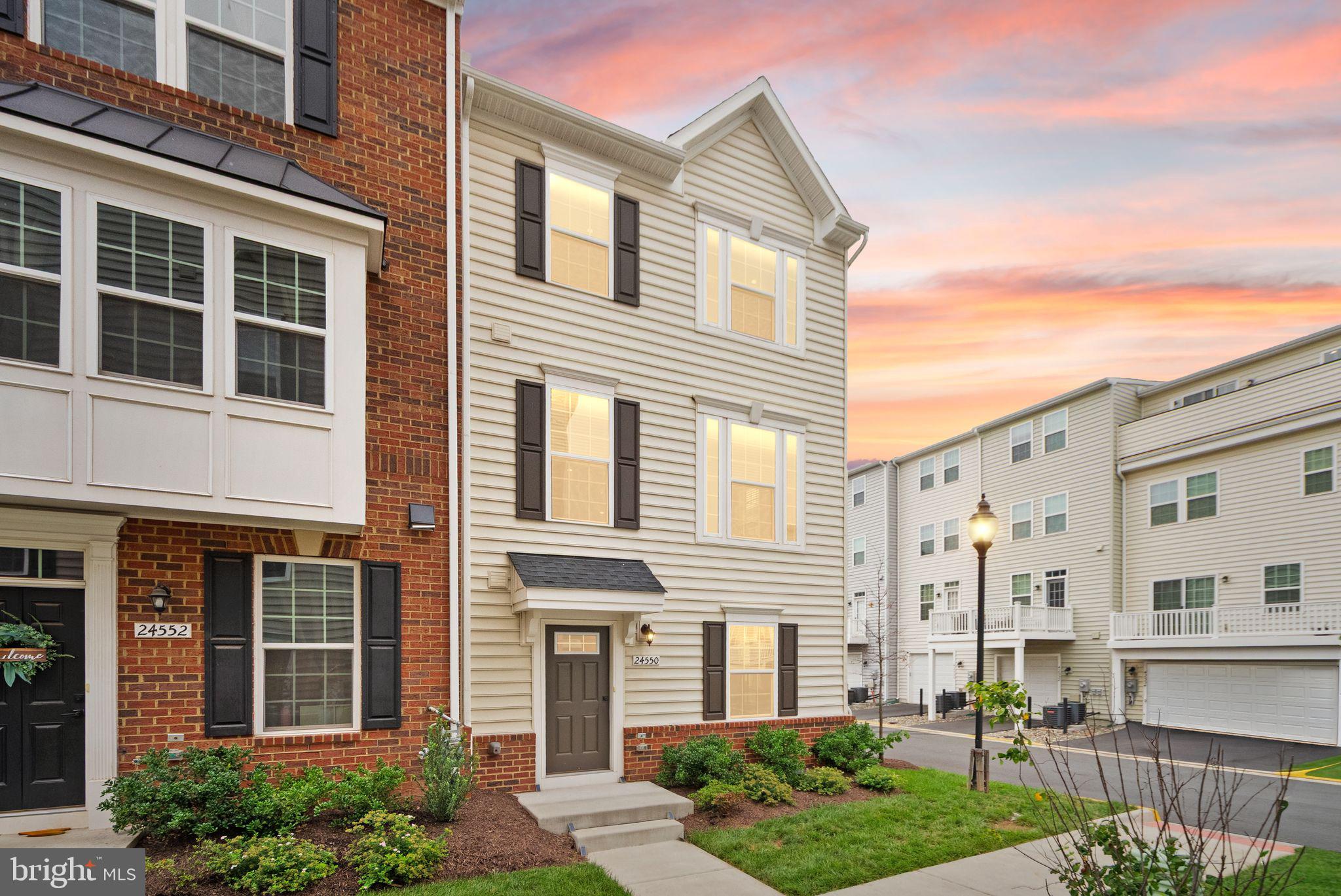 Built in 2022 and thoughtfully upgraded, this stunning end-unit townhome offers four finished levels of stylish living, four bedrooms, three full baths, two half baths, and the added benefit of seller-owned solar panels that significantly reduce monthly electric costs.

Step inside to a flexible entry-level living space that's perfect as a family room, home office, playroom, or guest retreat. This level also features a convenient half bath, generous storage, and direct access to the oversized two-car garage, complete with durable epoxy flooring. A two-car driveway provides additional parking for family and guests.

The heart of the home is the bright, open-concept main level, designed for both everyday living and effortless entertaining. The gourmet kitchen features stainless steel appliances, a spacious center island with seating, abundant cabinetry, a large pantry, and direct access to a private terrace—ideal for morning coffee or dining outdoors. The adjoining dining area easily accommodates a large table, while the sun-filled living room is enhanced by expansive windows that fill the space with natural light. A conveniently located powder room completes this level.

Upstairs, the spacious primary suite serves as a peaceful retreat, featuring a large walk-in closet and a beautifully appointed en-suite bath with a walk-in shower. Two additional bedrooms, a full hall bath, and a conveniently located laundry area complete the third level.

The top floor offers exceptional versatility with a private fourth bedroom, full bath, and access to a second outdoor balcony. Whether you envision a guest suite, home office, fitness studio, or media room, this flexible space adapts to your lifestyle.

With major systems just four years old, energy-saving solar panels, modern finishes throughout, multiple outdoor living spaces, and the sought-after privacy of an end-unit location, this move-in-ready home offers the perfect blend of comfort, efficiency, and contemporary living.