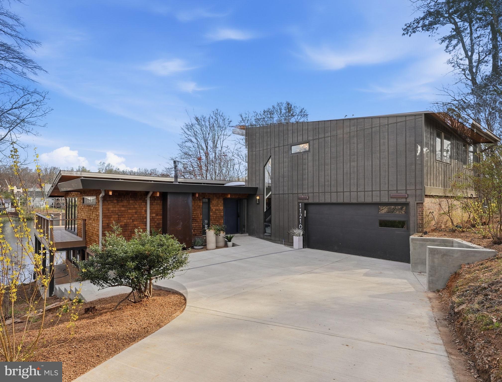 Open House Saturday May 9th from 1-4 and Sunday May 10th from 1-4
Brand new price ! Don't miss out on this amazing opportunity.

11216 S. Shore Rd Reston VA  ** On Lake Anne **

A 6 bedroom 5 1/2 bath, modern lakefront home built for the way you actually want to live.

From the moment you  step onto the main level, Lake Anne stretches out before you wall to wall.  The sunsets here will rearrange your evening plans.  The light drops into the water and paints everything gold.

This is an original mid-century home on one of Lake Anne's most coveted waterfront parcels, comprehensively reconstructed from the inside out. The renovation substantially expanded the upper level footprint, introduced a fully finished lower level, and replaced every mechanical, plumbing, and electrical system in the house.  The setting and architectural bones are Lake Anne.  Everything else is new.

** Main Level **

Open-plan living organized around uninterrupted water views, expressed through expansive glazing and a fluid layout designed for gathering.  The kitchen anchors the space with a commercial-grade dual-fuel 48" range, industrial-sized vent hood with external blower, extra-large workstation sink, walk-in pantry, and an oversized island built for prep and seating.  Custom maple cabinetry, quartzite and quartz counters, well-designed task lighting, and hidden outlets throughout.  A gas fireplace warms the living area, while a wraparound Timber-Tech composite deck extends the footprint outdoors through three 10' sliding doors.  This level also includes a main-level ensuite bedroom, a dedicated laundry room with utility sink and built-in cabinetry, and a half bath.

** Upper Level **

The primary suite is the showpiece:  floor-to-ceiling glass spanning the full width of the lake.  Step directly onto a private terrace for morning coffee or an evening drink with nothing but water and sky.  The suite includes a walk-in closet and a spa-caliber bath with soaking tub, separate double shower, and heated floors.  Two additional bedrooms share a second full bath finished with cohesive designer selections.

** Lower Level **

A fully self-contained residence with its own exterior entrance onto a covered lakeside porch.  Two generously scaled bedrooms, each with a private full bath.  Full kitchen with premium full-sized appliances and counter seating.  Dedicated side-by-side laundry.  Living and dining areas centered around a second gas fireplace.  This level functions as a true second home within the home.

** Systems & Infrastructure **

Comprehensive modernized:  three independent heat pump zones, 400-amp panel with Level 2EV charging port,  duel water heaters (tanked and tankless).  Architectural lighting design and fixtures in all spaces.  The exterior features a maintenance-free standing seam metal roof, pre-dipped cedar shingle siding, triple-paned custom windows, and custom low-voltage landscape lighting.

** On the Water **

A private floating dock is included, equipped with an electric motor for cruising the lake, with direct access to the water and trails from one of Reston's most architecturally significant lakefront communities.