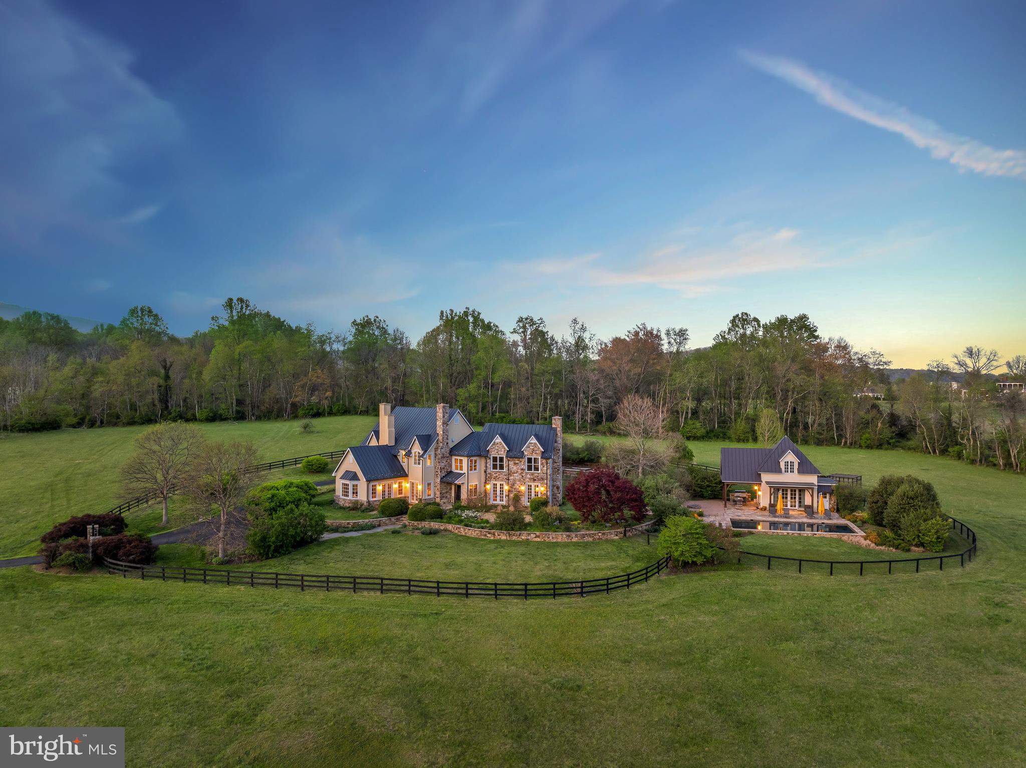 Stillpoint Farm is an incredible offering on 21 acres with a beautiful, well-constructed stone and stucco residence, guest house, pool, detached garage, extensive gardens, and sweeping views of your own privacy and serenity.  Just minutes outside of Little Washington, enjoy blue ridge mountain vistas from every direction.  Built in 2002, the construction and details are of high-quality with a thoughtfully designed floorplan.  The chef’s kitchen includes Wolf & Subzero appliances, custom cherry cabinets, granite counters, a large center island with sink, and is open to a charming dining area and fireplace.  There is a butler's pantry/mudroom off the kitchen with rear access from the garage. The kitchen is open to a two-story living room with its 24-foot ceilings and stately wall-to-ceiling wood-burning fireplace.  The main level includes a convenient en-suite bedroom.  The primary suite is tastefully designed with views from all windows, a balcony, large walk-in closets, and a luxurious bathroom & soaking tub.  The upper level has a cozy open sitting area ideal for a variety of uses and an additional en-suite bedroom that also has access to the balcony.  The lower level has a large work-out area, a climate control wine room, and a movie theater.  The gunite, saltwater pool is well positioned in between the gardens and guest house. The guest house features a pocket kitchenette, a stone shower, and loft upper-level bedroom. French doors open to a bluestone terrace, an outdoor kitchen, large built-in Viking grill, covered dining, and fire pit. 
In addition to the famed Inn, Little Washington has several other cafes and galleries. Thornton Gap and Shenandoah National Park are within 20 minutes.  High speed comcast internet installed.  Property includes 2 parcels, the  1 acre lot is buildable with access to Piedmont Avenue.