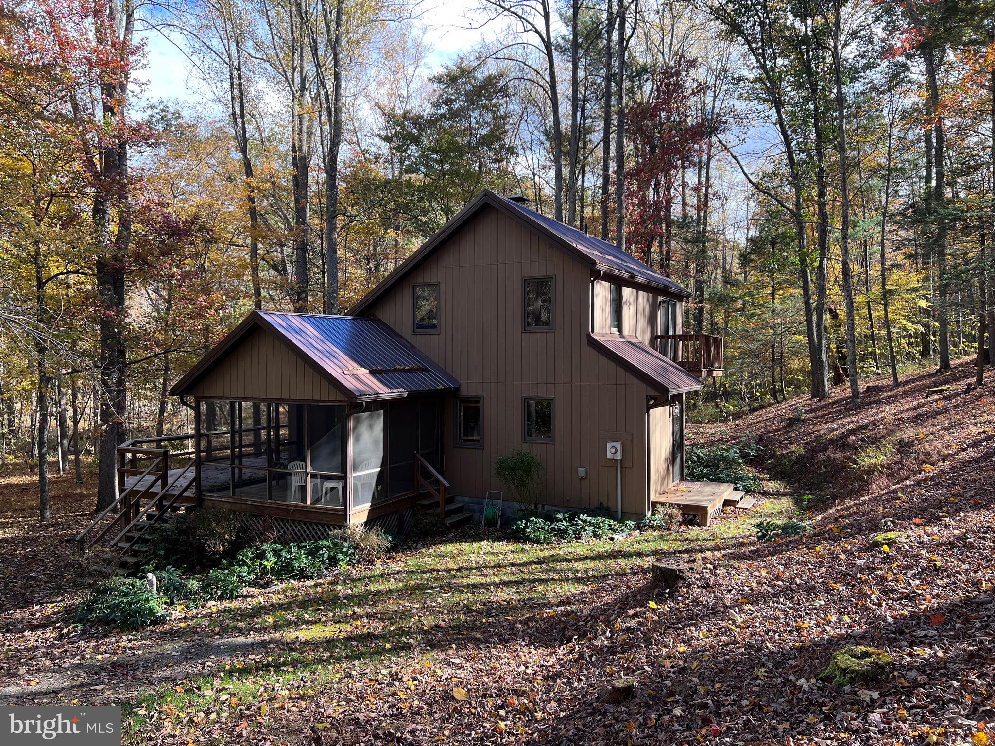 This property has 205' of frontage along the Cacapon River!   Imagine the season's from your home in WV.   Have lots of fun enjoying your very own private frontage along the river and enjoy all the colorful leaves in the fall!  This charming home features: Great Room with high wood ceilings, wood burning fireplace and balcony overlooking the Great Room. Fully equipped Kitchen with Closet & stack washer & dryer, main level Bedroom and dual entry Bath. Upper level features 2 additional Bedrooms (1 BR is open) with a Jack and Jill Bath. Enjoy the screened in porch, and the path to the river front access. Situated on 3 acres in Morgan Wood Subdivision.  Across the river is a 51 acre Wildlife Sanctuary. There is also a common area along the river just as you turn into Morgan Woods. Pack your bags and come relax most furnishings convey!  Frontier Internet and Air B&B's are permitted.