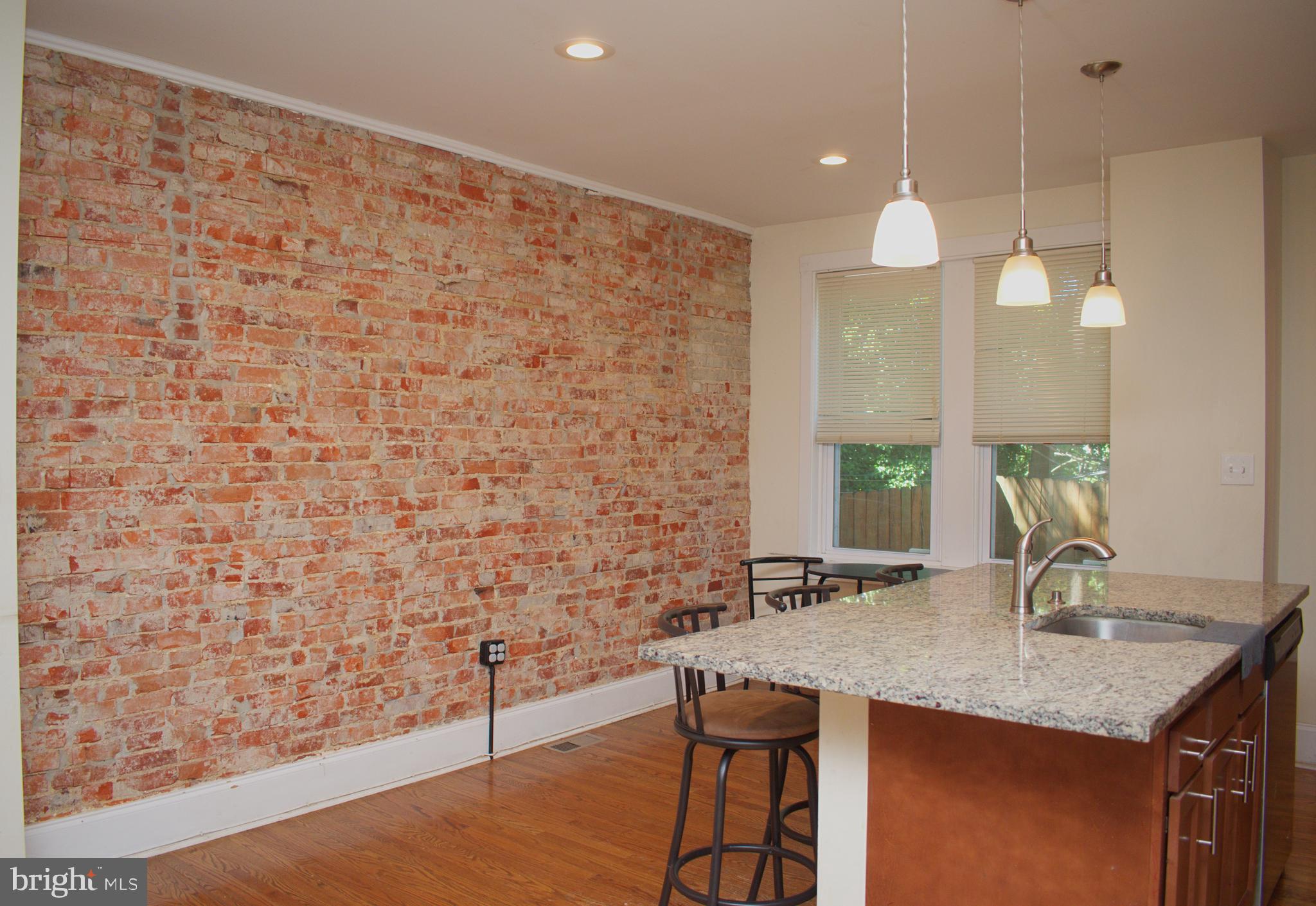 Welcome home! This charming 3 bedroom, 1 1/2 bath row home is full of character! With its beautiful hardwood floors throughout, exposed brick walls and updated lighting, you are bound to fall in love! The living room is full of natural light and boasts an original fireplace. The open floor plan flows nicely into the dining room and kitchen where you will appreciate an amazing center island. The galley-style kitchen offers ample cabinets and prep space. The updated appliances and granite countertops may be just what you are looking for! Just off the kitchen you will find the rear deck. The 2nd floor offers 3 decently sized bedrooms, each with adequate closet space. You will also find an updated hall bath with modern tile and an amazing skylight. The lower level is finished and includes tall ceilings, a storage room, a laundry room and a half bath. The flooring can be easily reinstalled once you have moved in. There is a door leading to the rear of the home where 1-car can park comfortably. The front porch is quaint and welcoming, allowing you to sit outside and enjoy the swaying trees. Other great features of this home include CENTRAL AIR, high hats throughout, updated ELECTRICAL (2016), updated PLUMBING (2016), etc. We are located just minutes from Tiger Woods' Cobbs Creek Golf Campus where you can find a new driving range, an Education and Community Center and a state-of-the-art golf course! Come and make this charming home - yours! ***Ask me about FTHB Grants up to $12,000.00 just for buying a home in this community!!***