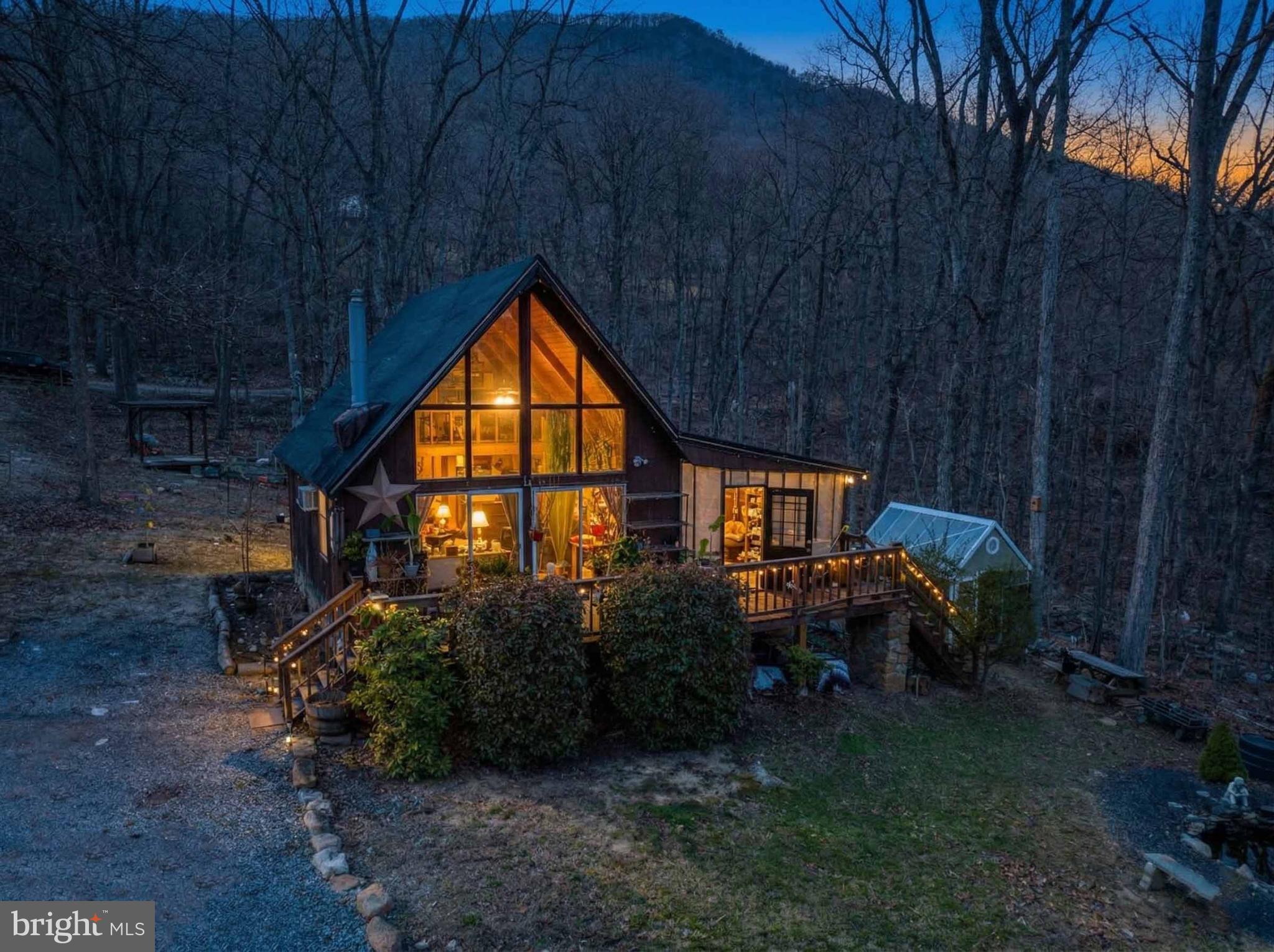 Tucked deep into the woods of Shenandoah Forest, this one-of-a-kind mountain retreat is not for the faint of heart, but for the right buyer, it’s an opportunity to create something truly special.
Surrounded by nature and set on a private, secluded just over an acre parcel, this rustic A-frame-style home offers soaring ceilings, a wall of glass that brings the outdoors in, and a setting that feels worlds away from the everyday hustle. Whether you’re looking for a weekend escape, short term rental opportunity, a creative renovation project, or a basecamp for adventure, this property delivers unmatched character and potential.

Inside, you’ll find a warm, cabin-inspired interior with wood finishes, a cozy wood stove, and an open living space filled with natural light. With one full bedroom and a airy loft, the home has been well lived in over the years and is ready for its next chapter It offers a creative canvas for those with vision and a willingness to roll up their sleeves.

Access to the property is part of the adventure situated on rugged terrain, all-wheel drive or four-wheel drive is strongly recommended. This property is being sold strictly as-is, with buyers welcome to pursue financing options that align with the property's condition.

If you’ve been searching for something off the beaten path, where privacy, potential, and personality matter more than perfection—this might just be the one. Additional adjoining .57 acre lot available for purchase or can be combined with the prefect offer!