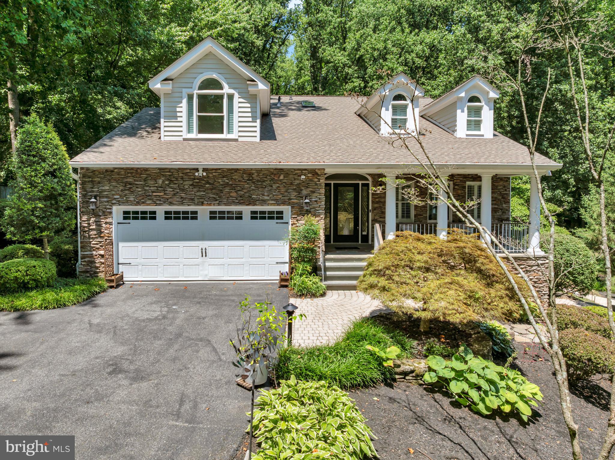 From the moment you arrive, it’s clear that 1173 Parrish Place is something special. Surrounded by mature trees and thoughtfully designed landscaping, this beautifully updated home offers exceptional privacy, expansive outdoor living spaces, and access to the award winning Severna Park school district. Situated on nearly an acre of land and offering over 3,000 square feet of living space, this 4 bedroom, 3.5 bathroom residence provides the perfect balance of peaceful retreat and everyday convenience.

A long driveway provides abundant parking in addition to the attached two car garage, while natural stone accents, professional landscaping, and a stunning covered front porch create impressive curb appeal. The property’s setting feels worlds away from it all while remaining minutes from everything Severna Park and Arnold have to offer.

Inside, freshly painted interiors and abundant natural light create a warm and inviting atmosphere. Skylights brighten the spacious front living room, while hardwood flooring extends throughout the main level. The fully renovated kitchen features quartz countertops, custom two tone cabinetry, stainless steel appliances, designer pendant lighting, subway tile backsplash, and a built in coffee bar complete with custom cabinetry and a beverage refrigerator. Adjacent dining and gathering spaces create a seamless flow for everyday living and entertaining.

Just beyond the kitchen, a second family room offers custom built ins, a gas fireplace, recessed lighting, and direct access to the rear deck overlooking the backyard. A renovated half bathroom, laundry room with storage, and access to the attached garage complete the main level. The garage is also equipped with a dedicated 240 volt outlet for electric vehicle charging.

Upstairs, the spacious primary suite features a large walk in closet and an ensuite bathroom complete with dual vanities, a soaking tub, and a separate shower. Two additional bedrooms share an updated hall bathroom featuring tile finishes and a skylight that fills the space with natural light. Durable engineered flooring extends throughout the upper level.

The finished walkout lower level provides exceptional flexibility with a large recreation area, a full bathroom, and a fourth bedroom. A kitchenette and serving area near the walkout entrance create the perfect setup for poolside gatherings, guest accommodations, or multigenerational living.

Outside is where this property truly shines. A spacious deck overlooks an expansive lawn rarely found in the area, offering endless possibilities for recreation, gardening, or simply enjoying the peaceful surroundings. Natural stone steps lead to an impressive private pool retreat surrounded by extensive paver hardscaping and mature landscaping. The pool features a retractable cover, expansive patio areas, dedicated lounging space, and a stunning pavilion complete with electric service, a ceiling fan, and television hookup. A pool storage shed and pathways connecting the various outdoor living areas complete the experience, creating a backyard designed for relaxation and enjoyment.

Additional updates and features include dual zone HVAC, a new HVAC system installed in 2024, public water service, and numerous thoughtful improvements throughout.

Located within the highly sought after Severna Park school district and just moments from shopping, dining, parks, the B&A Trail, Downtown Annapolis, and major commuter routes to Baltimore and Washington, this home offers a rare opportunity to enjoy privacy, space, and convenience in one exceptional property.