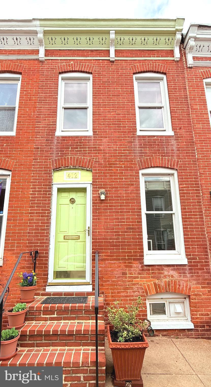 Welcome to 412 Sanders in historic Federal Hill, a home where true pride of ownership shines through every detail.  This charming rowhome nestled on a peaceful block has been thoughtfully updated over the years, offering modern comforts while maintaining its original character.  Inviting living room with refinished hardwood flooring, built-in bookcase and separate dining area.  Enter the kitchen through French pocket doors made from solid wood, repurposed from a home in Guilford.  The kitchen is a standout, with updated counters, appliances, painted cabinets, a pot rack, along with easy-to-access rolling racks in all lower cabinets except under the sink.  Upstairs you will find two sizable bedrooms and a recently updated bathroom (2020), including new tile flooring, a raised vanity, a higher commode, and an extra-deep tub.  Enjoy outdoor entertaining with a newer poured concrete patio, wood fence for privacy and a freshly painted back exterior.  Plenty of space for storage in the roomy basement.  Other upgrades include,  electrical box (2025), screens to all windows (2025) and carpeting on the stairs and hallway (2022).  Comfort is key, with a newer HVAC system (2020).  The home also boasts a solid rubber roof and windows that have all been replaced to ensure peace of mind for years to come.  Enjoy your quiet location while being within blocks of restaurants, shopping, grocery stores and beautiful parks (Riverside, Federal Hill, Locust Point Dog Park & Fort McHenry National Site).  Easy access to I-95, the Fort McHenry Tunnel, I-83 and Baltimore-Washington Parkway.  This is a home that has been carefully maintained and updated for modern living—truly move-in ready!