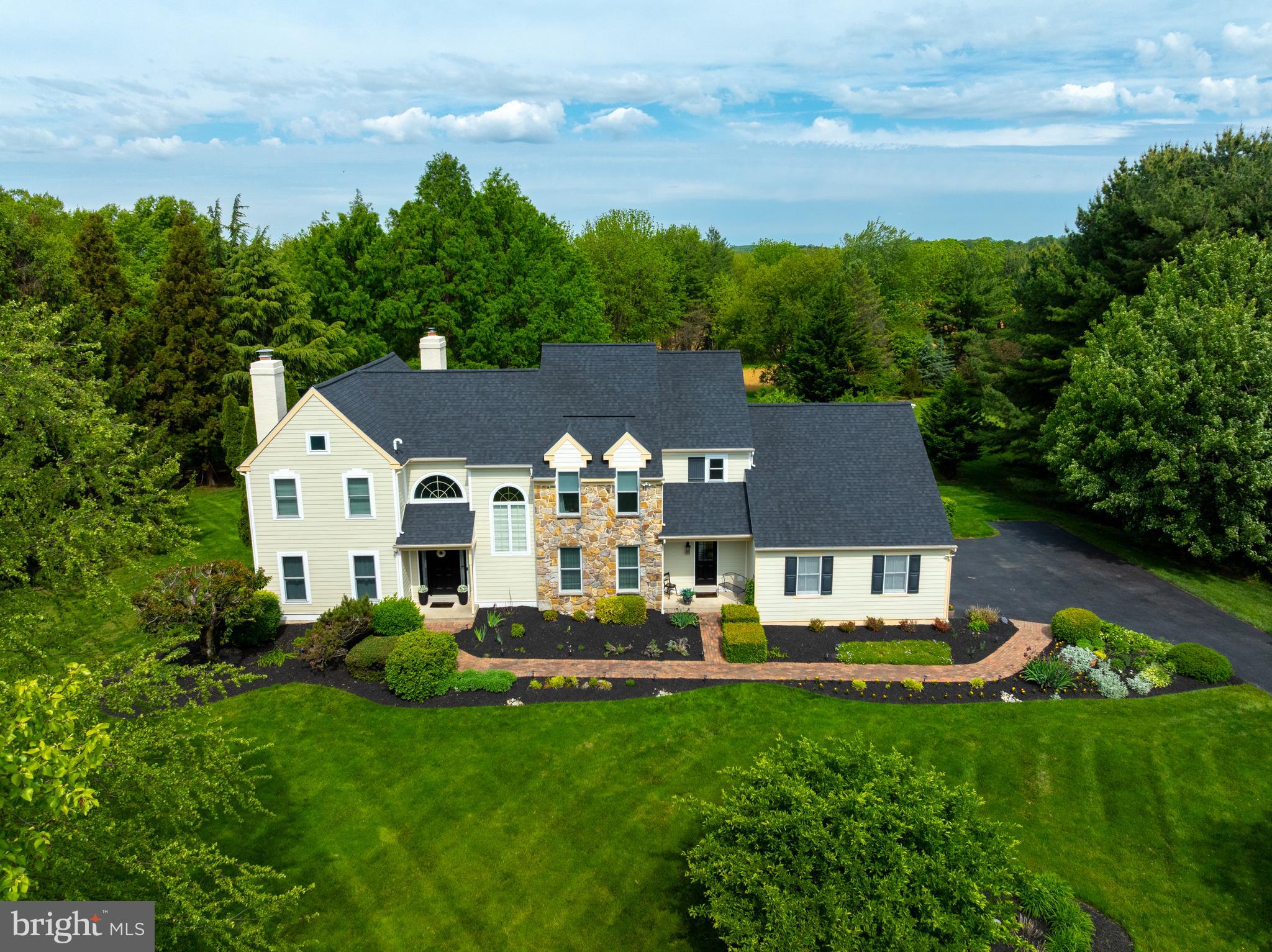 Nestled in the sought-after Hickory Hill community of Kennett Square and located within the award-winning Unionville-Chadds Ford School District, this completely move-in ready home is the perfect blend of timeless elegance, thoughtful updates, and exceptional care. Offering 4 bedrooms, 2 full baths, and 2 half baths, this stunning residence showcases modern improvements, beautiful craftsmanship, and exceptional indoor and outdoor living spaces — all just minutes from downtown Kennett Square’s acclaimed restaurants, boutique shopping, and the world-renowned Longwood Gardens. From the moment you arrive, the pride of ownership is undeniable. Major exterior upgrades include a newer roof (2023), as well as a complete stucco remediation in 2021 with maintenance-free Hardie Plank siding, Azek trim, and ProVia windows and doors. A Generac generator provides additional comfort and peace of mind. Inside, spacious light-filled rooms create a warm and inviting atmosphere throughout. The formal living room is highlighted by a pristine fireplace, while a private study with French doors offers the ideal work-from-home retreat. An elegant dining room with detailed moldings sets the stage for memorable gatherings. Hardwood flooring spans nearly the entire first floor, creating a seamless flow from room to room. At the heart of the home is the designer “Kitchen by Waterbury,” featuring a quartz center island, glass-front cabinetry, recessed lighting, stainless steel appliances, under cabinet lighting, soft close drawers and exceptional functionality for everyday living and entertaining alike. The kitchen opens effortlessly to the impressive family room, where a dramatic floor-to-ceiling stone masonry fireplace and oversized windows frame the scenic backyard views. Outdoor living is equally exceptional with an incredible screened-in porch and a two-tier low-maintenance deck overlooking the completely flat, private backyard. Backing to neighborhood open space, the property offers both serenity and beauty, enhanced by six mature fruit-producing trees. Upstairs, an open loft provides versatile living space perfect for a home office, reading nook, or den. The spacious primary suite features vaulted ceilings, two walk-in closets, a separate vanity area, and dual sinks designed for everyday convenience. Three additional generously sized bedrooms with ample closet space and a full bath with double sinks complete the upper level. The mostly finished lower level offers outstanding flexibility, including a potential fifth bedroom or guest suite, a large recreation/game room, space for exercise equipment, multiple storage closets, and an unfinished storage area. Beautifully maintained and thoughtfully updated throughout, this exceptional Hickory Hill home offers luxurious comfort in one of Chester County’s most desirable locations, combining peaceful neighborhood living with easy access to vibrant dining, shopping, and everyday conveniences.