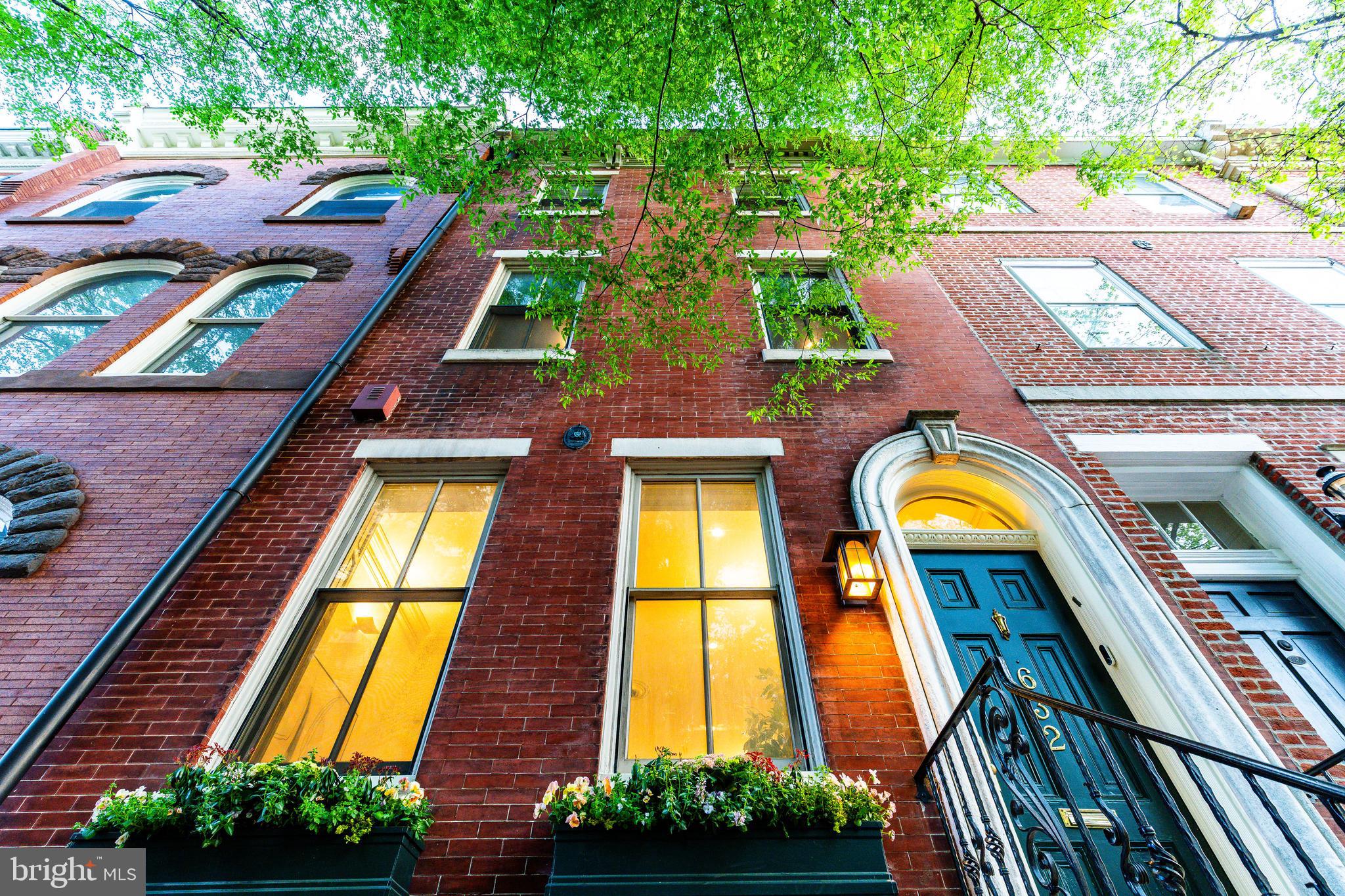Tucked away on one of the most picturesque, tree-lined blocks in Society Hill, 632 Spruce Street is a rare offering—a 4-bedroom, 3.5-bath historic townhouse spanning 3,775 square feet with the coveted luxury of a two-car attached garage. Just ONE block from Washington Square Park and built in 1805, this 18-foot-wide residence has undergone a comprehensive renovation—seamlessly blending timeless architectural integrity with elevated modern living. Every inch has been thoughtfully reimagined to offer refined city living in one of Philadelphia’s most coveted neighborhoods.
Enter through a gracious marble vestibule into a sun-soaked home graced by soaring ceilings, southern exposure, and original wide-plank pine floors—each one refinished to perfection. The formal living room features an elegant wood burning fireplace and oversized windows, while the dining room is appointed with custom built-ins and exquisite wall sconces. Throughout the home, over $85,000 in electrical upgrades were completed, including a new switchboard, added lighting, integrated sound wiring, and decorative enhancements. The kitchen has been updated with a striking new backsplash, radiant heat limestone floors, and a sunlit breakfast nook that overlooks the rear courtyard and expanded garage—now accommodating two side-by-side vehicles.
The second floor is anchored by a showstopping primary suite featuring a barrel-vaulted ceiling, a dramatic curved skylight, and a charming sitting area framed by bay windows. Custom Roman shades and re-stained hardwoods complete the look. The en-suite bath features a freestanding tub, marble tile, and exquisite, timeless hardware, creating a spa-like retreat within the comfort of home. A generous walk-in closet provides abundant storage. Just down the hall, the moody family room has been enhanced with expanded entry access, custom millwork, built-ins, and integrated speaker wiring.  A  laundry room completes the second floor.
The third floor offers two versatile bedrooms. The front bedroom is beautifully bright, wrapped in Cole & Son designer wallpaper, with new floorboards, custom closet units, window shades, and plush Stark carpeting. The rear bedroom, currently used as a cheerful playroom, features handsome beamed ceilings, bold Missoni carpeting, and direct access to a private deck with new patio flooring—creating a breezy escape in the heart of the city. Between the two rooms lies a fully renovated marble bathroom with a glass-enclosed shower—thoughtfully designed for both elegance and functionality.
The fourth-floor bedroom offers a peaceful escape beneath pitched ceilings and features an arched window that draws in soft natural light while framing leafy treetop views. The room’s tranquil palette, plush carpeting, and cozy proportions make it the perfect guest retreat, reading nook, or private home office. An impeccably updated full bath on this floor has been gut renovated, and two new skylights complete the airy, top-floor experience.
The current owners have spared no detail in their extensive and tasteful renovations: a fully rebuilt roof with copper siding and reinforced masonry (2020), removal of all knob-and-tube wiring, new water pressure pump, waterproofing in the basement, refinished original marble in the entryway, and full Google Home integration, including Nest climate control, doorbell, and security cameras. The unfinished basement has been fully gutted and sealed, ready for future expansion.
Located within the sought-after McCall School Catchment, this home offers not only historic elegance and high-end upgrades, but also access to acclaimed restaurants, cultural institutions, and the lush expanse of Washington Square Park. 632 Spruce Street is a one-of-a-kind opportunity to own a turnkey masterpiece in one of Philadelphia’s most beloved neighborhoods.