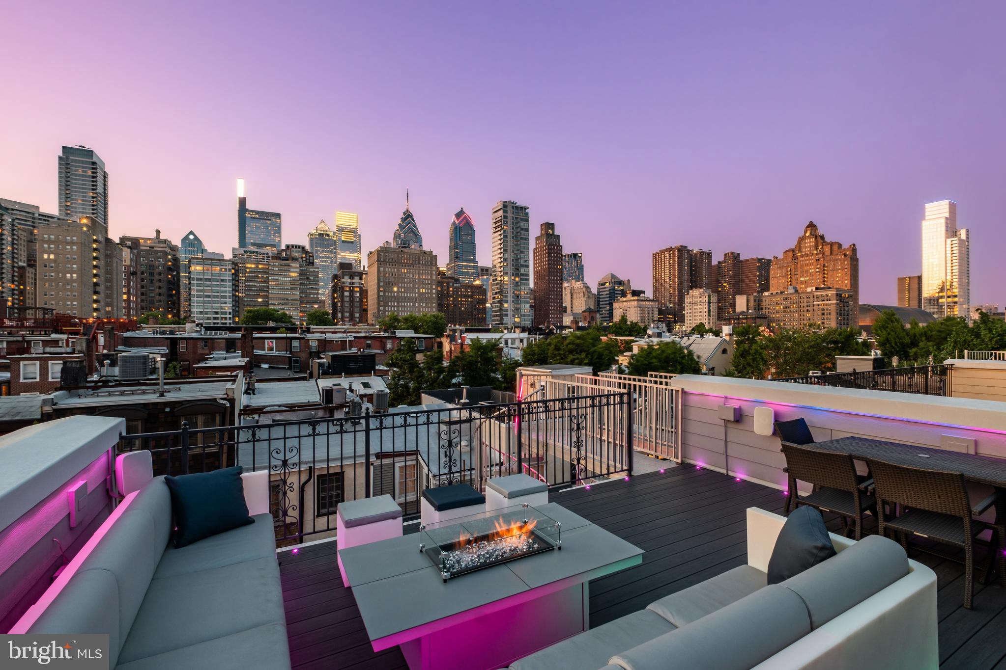 Welcome to The Lombard Estates—an exceptional luxury residence ideally situated steps from Rittenhouse Square, a short walk across the bridge to UPenn, CHOP & HUP & located in the prestigious Greenfield School Catchment! Offering over 4,100 square feet of impeccably designed living space, this expansive home blends sophistication, comfort & convenience in one of Philadelphia’s most sought-after locations. Complete with 4 bedrooms, 4.5 bathrooms, a finished basement, private elevator, and a 2-car garage, every detail has been thoughtfully curated for elevated city living. Topping it all off is a spectacular 2-tiered rooftop deck showcasing completely unobstructed skyline views—some of the most breathtaking in all of Philadelphia!  Enter through an elegant foyer, currently styled as a home office, with convenient access to the attached 2-car garage with generous storage. An in-home elevator enhances everyday convenience by allowing easy movement between all levels. It simplifies daily routines and adds flexibility, creating a more comfortable & functional living environment for a variety of needs over time. The second level unfolds as the heart of the home, thoughtfully designed for both daily living and elegant entertaining, with a spacious living & dining area highlighted by gleaming hardwood floors, custom built-ins, a gas fireplace, and charming Juliette balcony. The living room entertainment center features centralized control of built-in speakers, allowing you to enjoy music throughout the living & dining areas, kitchen and even the roof deck! The chef’s kitchen is impeccably appointed with premium appliances, including a Viking refrigerator, Wolf cooktop & double oven, a Miele hood, and Bosch dishwasher. Quartz countertops, high-end cabinetry, and a sleek backsplash blend functionality with sophisticated design. A discreet powder room completes this level. The third level offers 3 generously sized bedrooms with hardwood floors, 2 full bathrooms, and a dedicated laundry room with a Whirlpool washer/dryer + utility sink. The top level is devoted to the luxurious primary suite, where skylights fill the space with sunlight. This serene retreat features a spacious WIC with custom built-ins, and a spa-like bath. The luxurious bath is appointed with a NuHeat radiant floor heating system, a tiled shower, dual vanities, and a soaking tub designed for ultimate relaxation. Just outside the primary suite, a convenient wet bar makes entertaining effortless as you step out onto your incredible rooftop deck. Whether hosting guests or enjoying a quiet evening, the 2-tiered outdoor space offers ample room for dining, grilling, and taking in sweeping, unobstructed views of the city skyline. The roof deck is fully equipped for outdoor dining, featuring a kitchen with a BBQ, refrigerator, and sink. A built-in gas fire pit creates the perfect setting for evening cocktails under the stars. Have peace of mind knowing that the fiberglass roof was refinished in 2019 prior to installation of Trex style roof decking. The fully finished lower level presents an impressive extension of living space, featuring a generous family room, a thoughtfully designed bar for entertaining, and a temperature-controlled wine cellar. The level also features a full bathroom and can easily be used as private living space for an au pair as an alternative option. The basement houses an in-home water filtration system along with an plenty of finished storage space. Smart home features include a Control4 automation system that lets you manage lighting, temperature & security with ease. Set programmable timers for lighting & adjust the climate throughout the home—all from an app, with remote access via subscription. Enjoy nearby dining favorites like Rival Bros, Friday Saturday Sunday, Illata, Pub & Kitchen & Southgate. Rittenhouse Market is just 3 blocks away. The Schuylkill River Park, Markward Playground, tennis courts & dog parks are all close by!