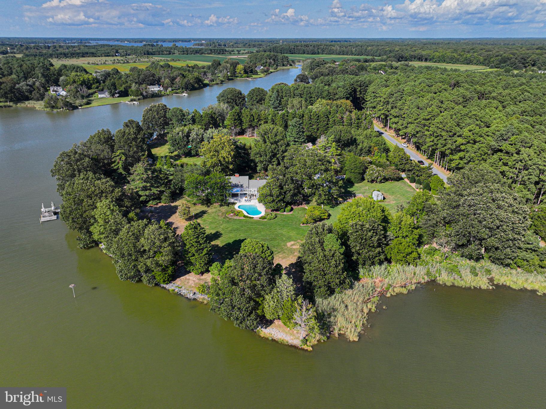 Welcome to your private Eastern Shore retreat! This amazing 4-bedroom, 4.5-bath Cape Cod is perfectly situated on a secluded peninsula, offering unparalleled tranquility and breathtaking waterfront views of Boone Creek located in beautiful Oxford, Maryland. The home offers an incredible blend of traditional elegance and modern luxury. An open and airy floor plan is bathed in natural light, with expansive windows framing the stunning water views from nearly every room. The living room has beautiful brick floors and a wood burning fireplace. You will also find a gas fireplace in the spacious family room. The bright and inviting sunroom has cathedral ceilings and walls of glass doors with water, pool, garden and patio views. The gourmet kitchen is a chef's delight, featuring high-end appliances, custom cabinetry, and a large center island. It flows effortlessly into the formal dining area which includes an additional fireplace for cozy and intimate dining experiences. Beautiful hard wood floors flow into several rooms. The main floor also hosts two private sanctuaries: an ensuite bedroom and a primary bedroom, each with private decks offering stunning water views. The primary suite's closet is a truly incredible, separate dressing room. A laundry room, a full bath, and a half bath complete the main level. Upstairs, two large bedrooms and a shared bath provide comfort and privacy for guests or family. Outside you discover a true entertainer's paradise. The property's unique peninsula location offers a wide expanse of water frontage, perfect for enjoying the Eastern Shore lifestyle. A large, sparkling in-ground pool is the centerpiece of the manicured grounds, surrounded by extensive hardscaping and lush landscaping, creating a resort-like feel. The detached two-car garage is enormous. There are raised beds in a fully fenced garden with a garden shed. The climate-controlled dock house offers endless possibilities for a gym, office, art studio or storage. The private dock provides water access for boating, kayaking, paddleboarding, fishing and crabbing on Boone Creek. With quick water access to Choptank River, Tred Avon River, Chesapeake Bay & Miles River, you can explore the best areas of the shore. This home is more than a residence; it's a lifestyle. Located just minutes from the historic town of Oxford, you'll have easy access to charming shops, restaurants, parks, the beach strand and the Oxford-Bellevue Ferry. This is a rare opportunity to own a piece of paradise on the Eastern Shore.