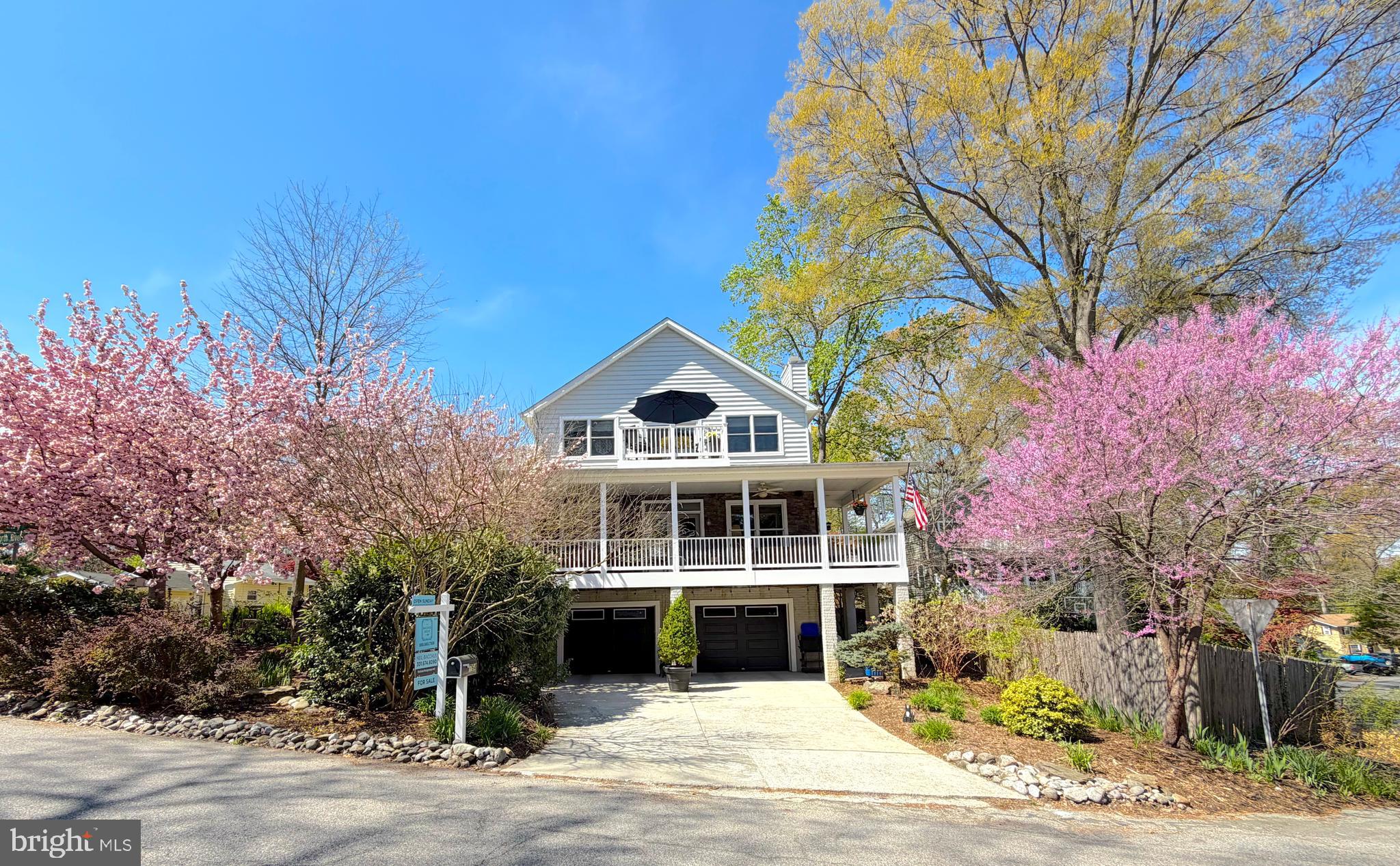 Discover a rare retreat in the coveted Herald Harbor riverside community, just steps from the Severn River. This exceptional 3 level, 3 Bedroom, 2.5 Bathroom residence boasts 3,692 sq ft and sits on a generous 7,788 sq ft corner lot, offering a refined lifestyle in a riverside community with timeless architecture, thoughtful design, and beautiful partial seasonal water views from the top level lookout balcony off the Master Bedroom.

This home features an expansive wraparound porch complete with seating areas, a swing, and is built with trex type composite decking. Elegant stone exterior construction richly complements the light-gray siding and white railings. An extra wide two-car garage plus two parking pads,  one just outside of the garage and the other on the side of the house, easily hold two cars each -4 total - provide plenty of room for residents and visitors alike.

Inside, rich white oak hardwood floors span the main level. Dramatic 10 foot ceilings in some areas make the home feel extra spacious and Anderson double hung windows add additional energy efficiency. A formal dining room with bay window sits to the left and is ideal for entertaining. To the right, a custom eat in alcove features rich hardwood built-in bookshelves and booth seating for a cozy gathering space just outside the kitchen. The spacious Gourmet kitchen boasts extra-long granite countertops, Cherry hardwood cabinetry, a five-burner gas stove, double oven, oversized breakfast bar with seating for five, a central vacuum and designer pendant lighting.

Open sight lines connect the kitchen to the sun-filled family room, featuring expansive windows, updated double doors that open to the deck, and a stunning wood burning stone fireplace for comfort and warmth all year long.

The upper level offers a spacious primary suite with hardwood floors, ceiling fan, large walk-in closet, updated sliding glass doors, private balcony with partial seasonal water views and a BainUltra air jet soaking tub, double vanity, and separate shower. Two additional bedrooms include one with plantation shutters and flexible use as an office, and another with an en-suite bath. An upper-level laundry and refreshment area includes washer/dryer, mini refrigerator, wet bar sink, and cabinetry.

The lower-level garage level provides two large open storage areas currently used as a wine cellar. There are 2 Dual Heat Pump Systems, one for each floor. One heat pump features an Aprilaire humidifier. A Generac 20kw whole-house generator adds additional comfort and peace of mind.

This residence is a 20 minute drive to downtown Annapolis.

Herald Harbor community residents can join the optional low cost Herald Harbor Citizens Association to enjoy access to a community center, beach, neighborhood restaurant, kayaking, hiking trails and boat ramp—offering a truly memorable waterfront lifestyle.