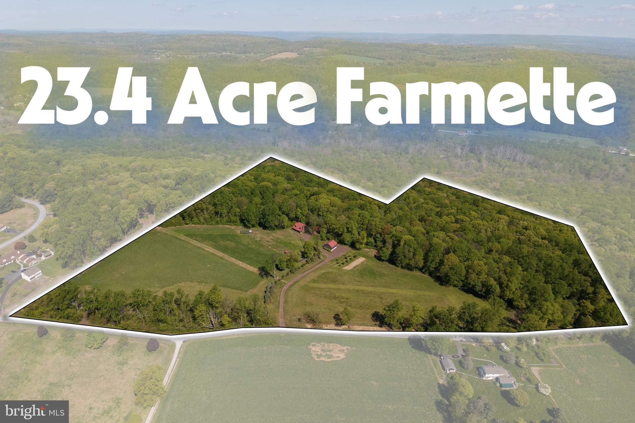 A rare opportunity to own a beautifully crafted custom home set near the center of 23.4 acres with a wooded backdrop, and overlooking level, tillable pastures at the end of a long, level driveway. The setting is exceptionally private, with topography, distance, and mature plantings screening the home from the road. The peacefulness is unlikely to change, two sides of the property border the wooded perimeter of Warwick Park, where a discreet footpath leads to the Charcoal walking & riding trail, and the 91-acre farm across the street is preserved. For buyers seeking substantial acreage, this property stands out: unlike many large-lot homes that sit close to the road on challenging terrain, this property offers level pastures in the heart of horse country. Zoned Residential/Agricultural, it allows a home-based business, two-family dwelling, farm animals, and up to 22 horses, according to the attached zoning ordinance. A sizable chicken house with a run is included. The taxes are low via Act 319, and it is believed one subdivision may be permitted. Comparable lots of similar size in the same school district, without a house, are listed at $925,000 & $1,150,000, suggesting the potential to recover a significant portion of the purchase price by subdividing & selling a parcel, if desired. The craftsmanship & vintage character of this 25-year-old Chester County homestead would be difficult to reproduce. The hand-hewn log home, bank barn, and stone walls create the feel of a centuries-old estate, while the 24x24 three-sided carport blends seamlessly with the setting. Inside, the open floor plan features ultra-wide random width flooring & soaring cathedral ceiling. Post-and-beam structural elements complement the stone fireplace, and the wood interior surfaces have been meticulously sanded smooth. The kitchen features custom cabinetry, granite countertop, 7-foot extra deep stainless sink sourced from Texas and opens to the great room. The home includes a spacious main-level bedroom & an upper-level bedroom suite with a clawfoot tub. The 23x15 loft could also accommodate two standard bedrooms or one large bedroom with a smaller loft area. The partially finished basement is warm & dry with superior exterior walls, 9-foot ceilings, and daylight walkout to a brick porch & adjoining stone patio, giving it a bright, comfortable feel. It also includes a custom bar/kitchen rough-in with walnut cabinets and sink provisions, along with a large powder room rough-in for a future shower - ideal for an in-law suite, family room, or additional bedrooms. The home is thoughtfully positioned to face southwest, allowing the 8x40 porch to shade the interior in summer while welcoming warm natural light in winter. Rather than traditional gutters, an in-ground drainage system directs roof runoff into the woods, except for small gutter over the front walk. Additional features include central vacuum & an exceptional heating system with multi-zone radiant floor heat in the basement, main level, and upper level. The bank barn's main level also has radiant floor heat, while the upper level uses radiators on the same system, and the carport has a rough-in for radiant heat if garage doors are added. Heating is supplied by either an oil-fired boiler or a wood-fired boiler. The wood-fired boiler is located in a handy 13x10 firewood storage room separated from the bank barn by a masonry wall. This smart setup allows either heat source to serve all buildings, with simple valve controls to heat selected buildings/areas as needed. The lower level of the 28x34, 2.5-car bank barn garage has 9’6” ceilings, two 10x8 insulated garage doors, power openers, and a sink. The upper level is insulated & drywalled, with a floor built from 1.75-inch tongue-and-groove planks topped with 3/4-inch plywood for a total thickness of 2.5 inches, likely suitable for hay, farm equipment, vehicle storage, accessed through a 10x8 insulated garage door cleverly concealed behind a barn door