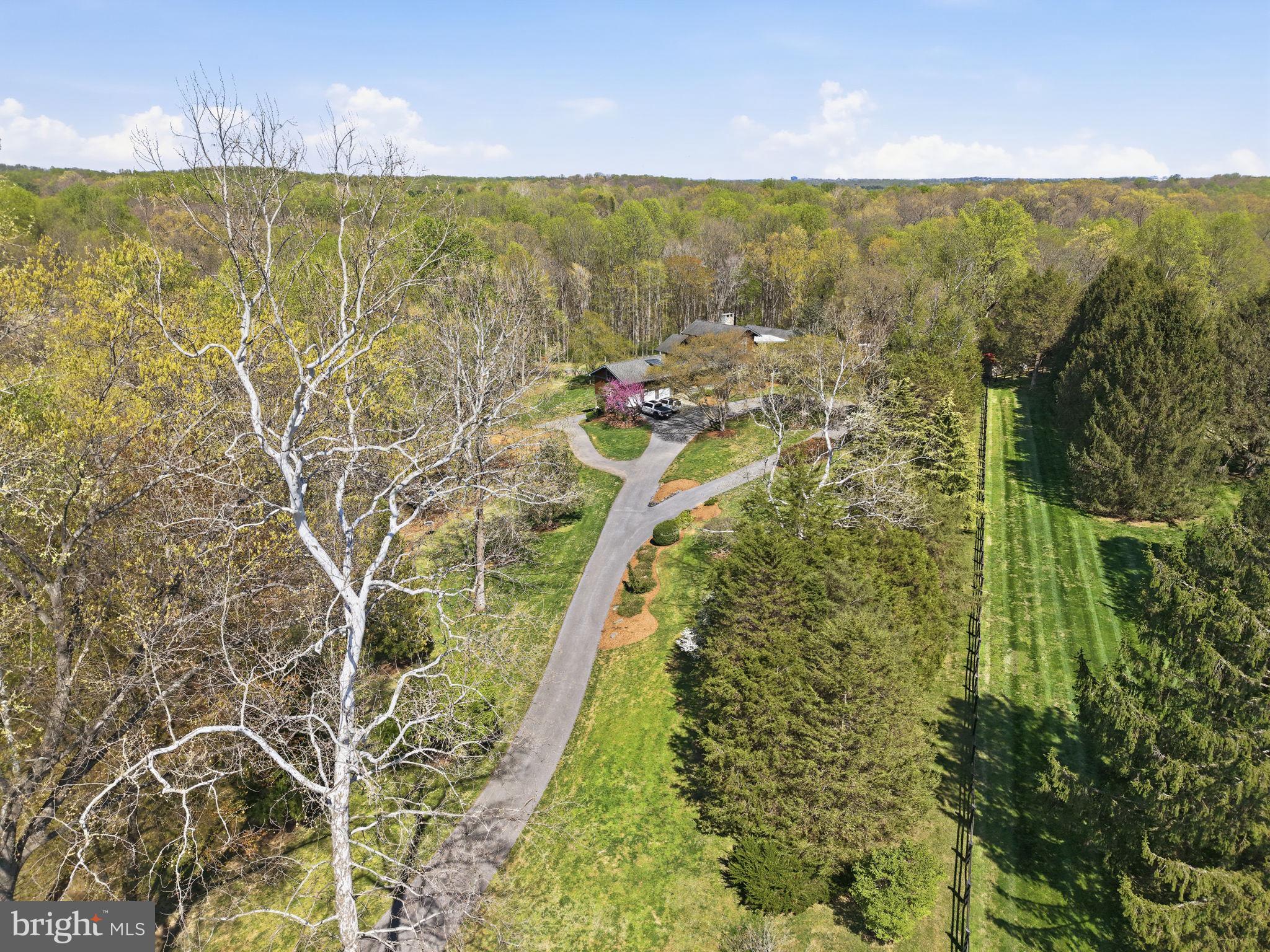 Tucked away at the end of a private drive and set on five breathtaking acres, this extraordinary estate offers the perfect blend of luxury, privacy, and natural beauty. With seven bedrooms, five full baths, and three half baths, the home is thoughtfully designed to accommodate both grand entertaining and everyday living at the highest level. Inside, soaring ceilings and an open floor plan create a light-filled, expansive feel, anchored by a beautifully renovated kitchen that seamlessly connects to the main living spaces. Every detail has been carefully curated to deliver both elegance and comfort. Step outside and experience a true retreat. A wraparound porch overlooks lush, professionally landscaped grounds, while the backyard unfolds into an oasis complete with outdoor fire pit, a tree house perched above the creek, a turf field with lights for endless fun, a zip line for the thrill seekers and peaceful trails that wind through the property and into the surrounding woods for those nature lovers. Streams gently flow behind the home, adding to the sense of serenity and escape. For those seeking a lifestyle that blends refined living with a touch of countryside charm, the property also features dedicated goat and chicken pens with electric and automatic doors, another small shelter with solar door, eight raised garden beds with a 8 foot high fence to protect the garden from those pesky deer, two fig trees, a mature raspberry patch and blackberry bushes, six small blueberry bushes (3-4yrs old),  all offering a unique opportunity for hobby farming or simply enjoying the land in a more meaningful way. Private, picturesque, and truly one-of-a-kind, this is more than a home, it’s an experience. And don’t forget you’ll never lose power during those storms with your brand new 45KW Generator powered by propane!